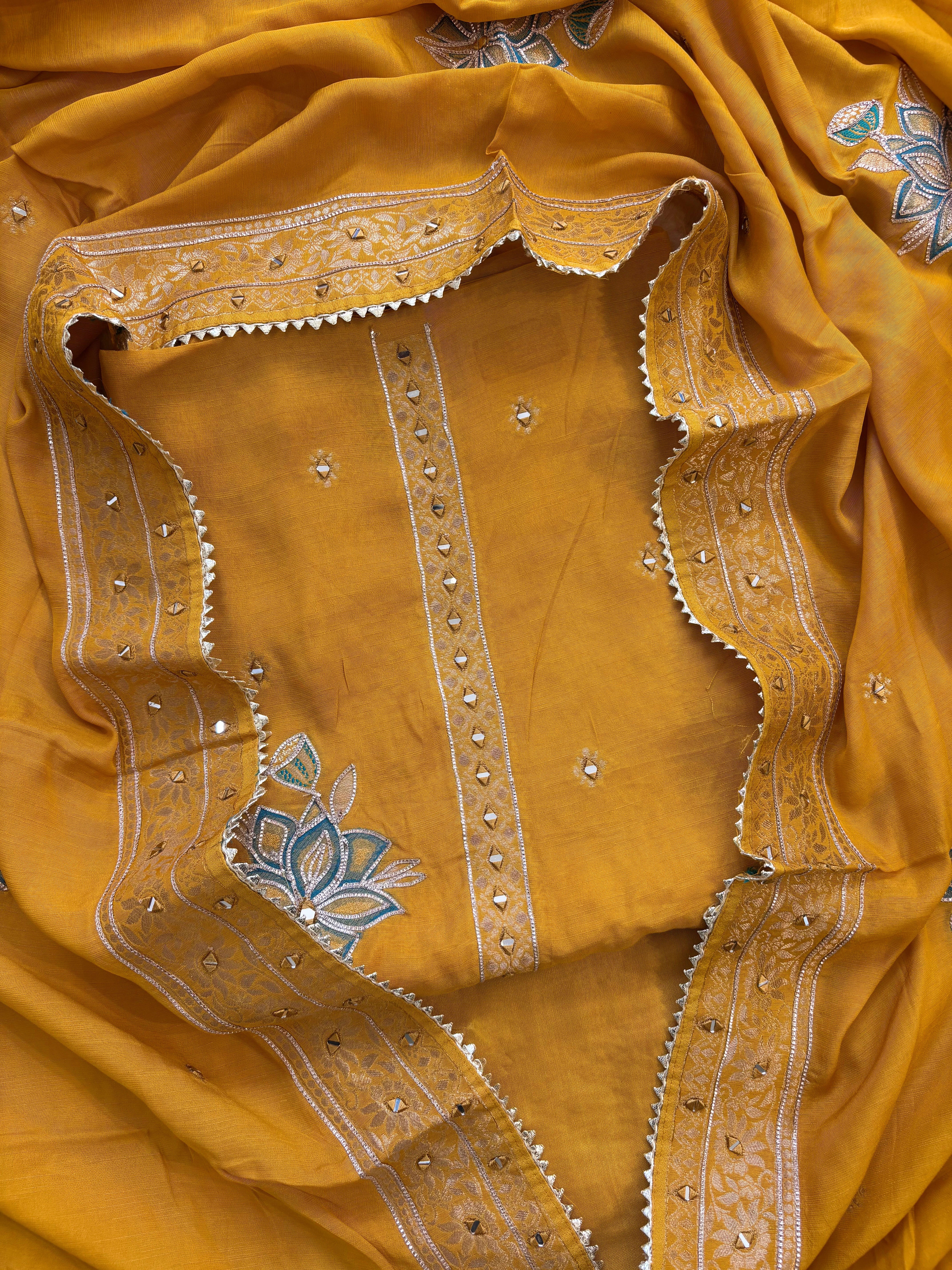 Mustard yellow linen suit with mirror work embroidery and applique floral dupatta.