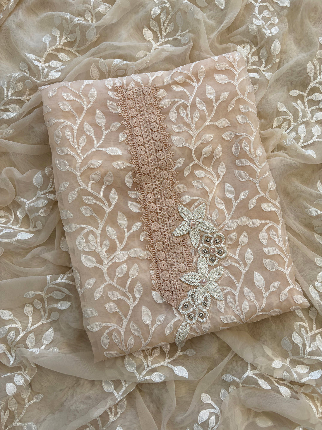 Peach organza suit with applique embroidery and moti bead embellishments, paired with embroidered organza dupatta.