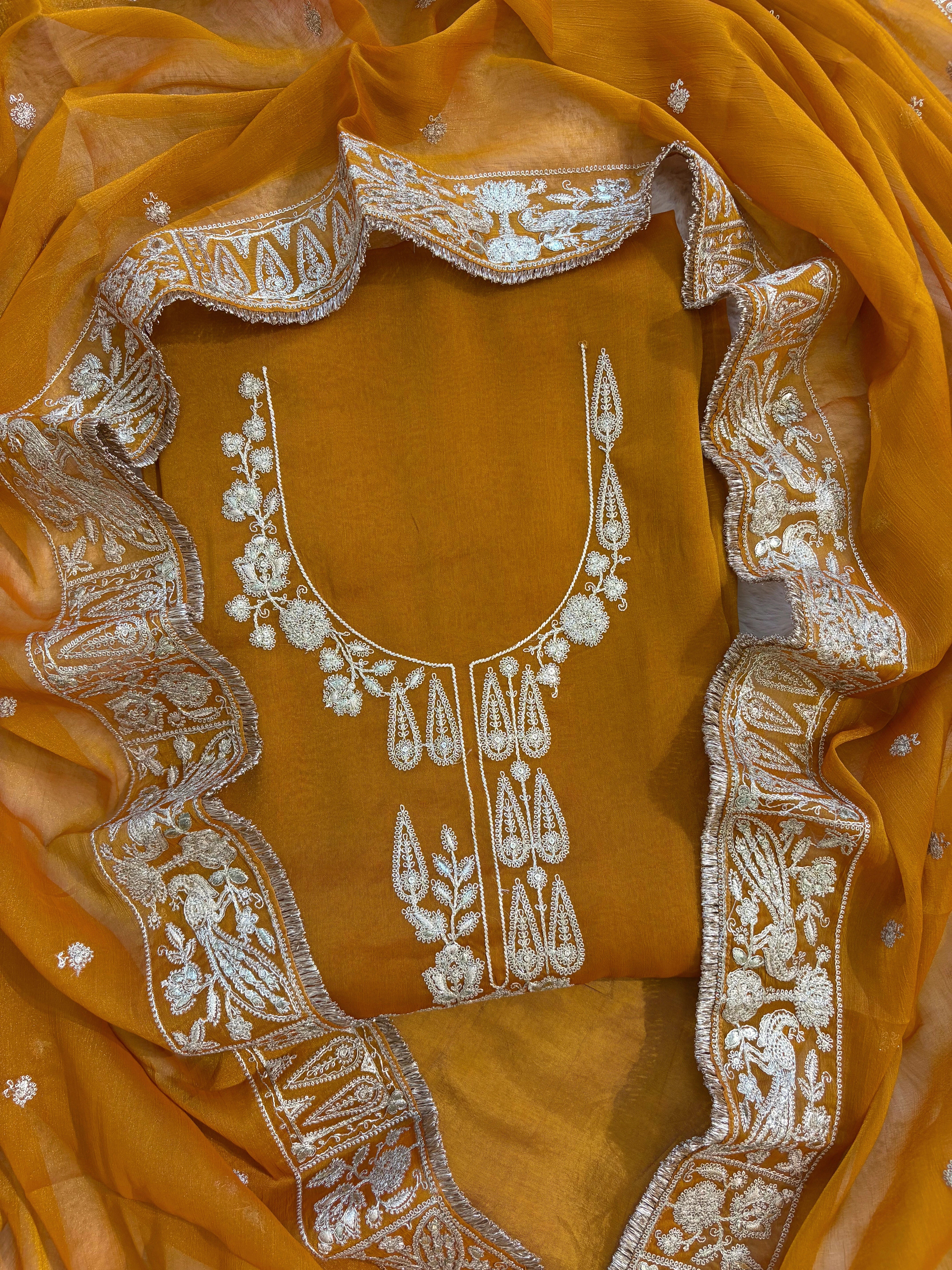 Mustard Yellow organza unstitched suit with golden zari embroidery and embroidered dupatta, ideal for weddings and festive celebrations.