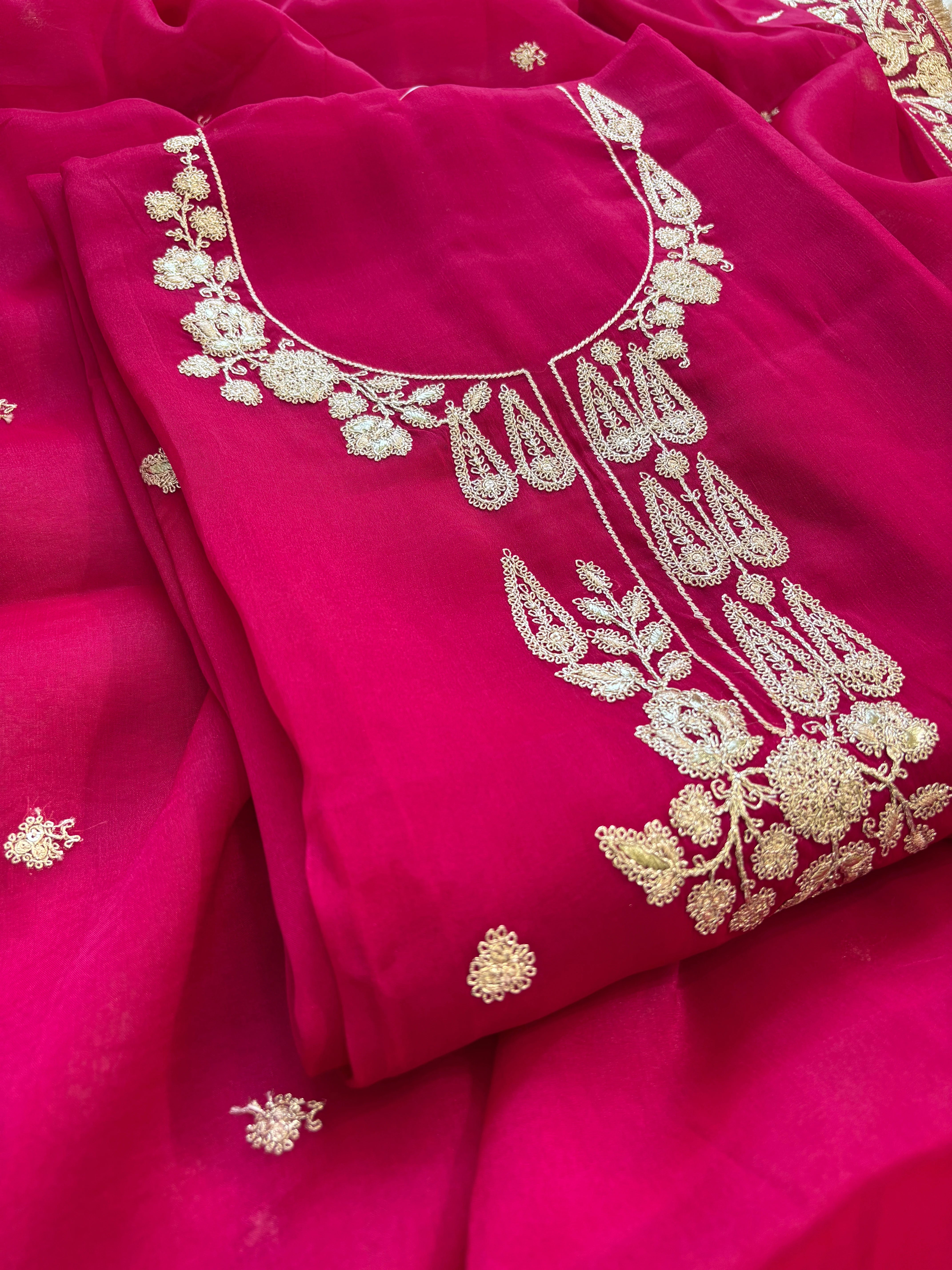 Hot pink organza unstitched suit with golden zari embroidery and embroidered dupatta, ideal for weddings and festive celebrations.