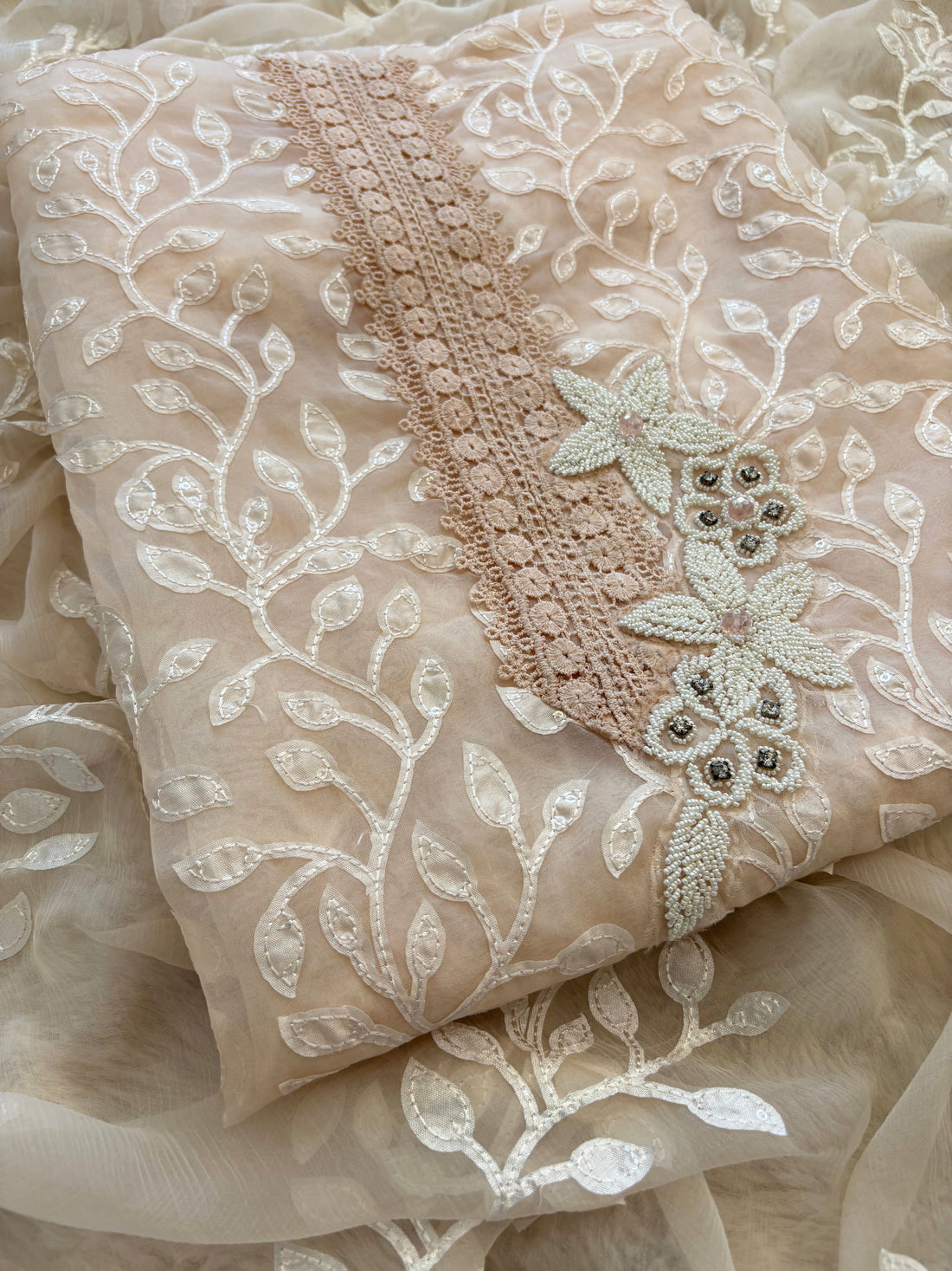 Peach organza suit with applique embroidery and moti bead embellishments, paired with embroidered organza dupatta.