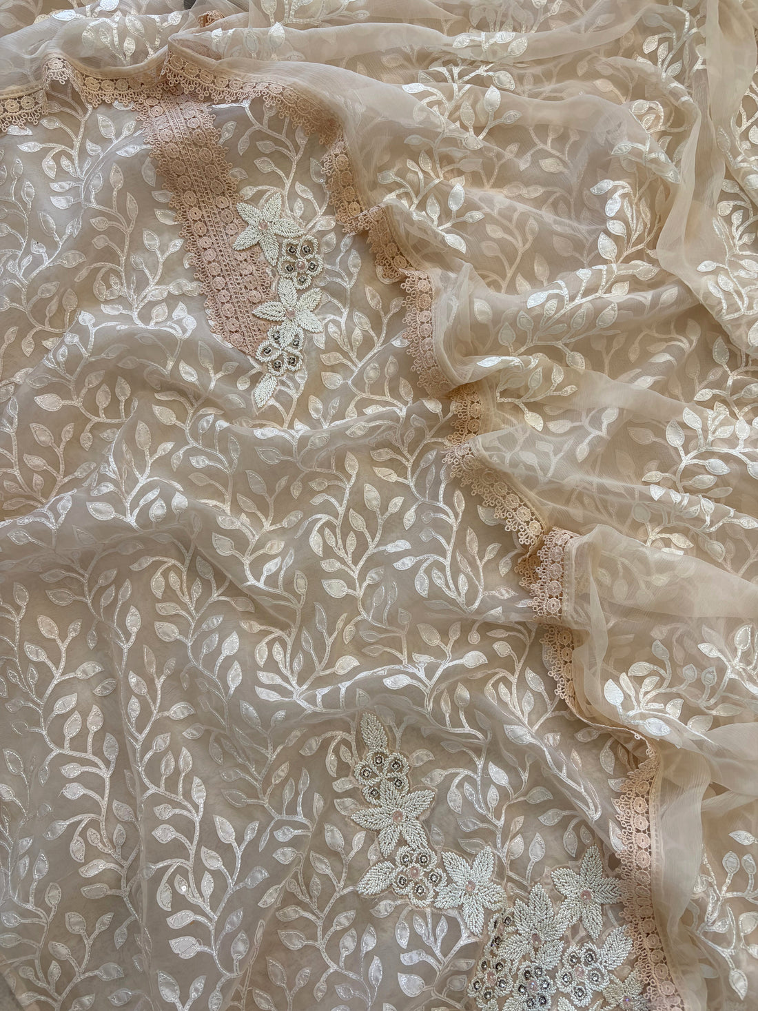 Peach organza suit with applique embroidery and moti bead embellishments, paired with embroidered organza dupatta.