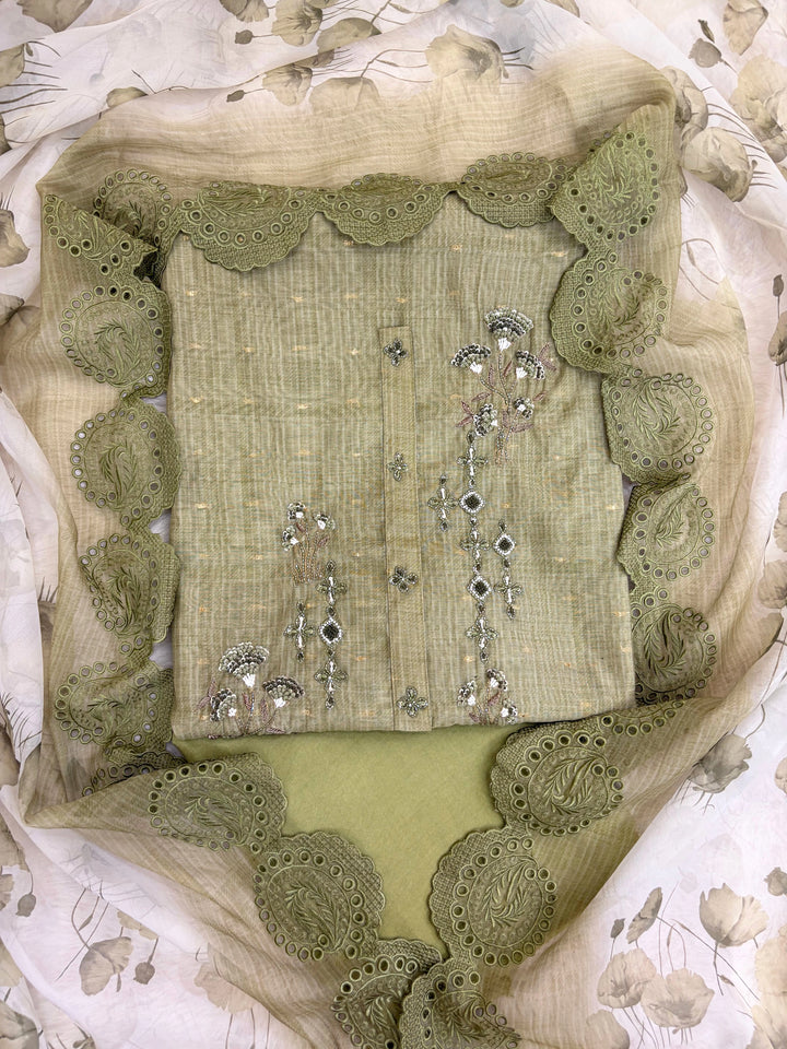 Olive green linen suit with floral threadwork, intricate lace detailing, paired with an organza dupatta with lace borders, ideal for weddings and special occasions.