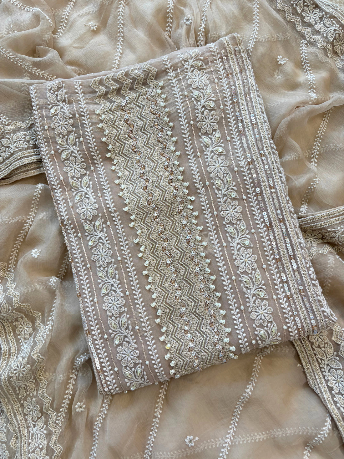 Nude georgette chikankari suit with moti and sequin highlighting, paired with chiffon chikankari dupatta.