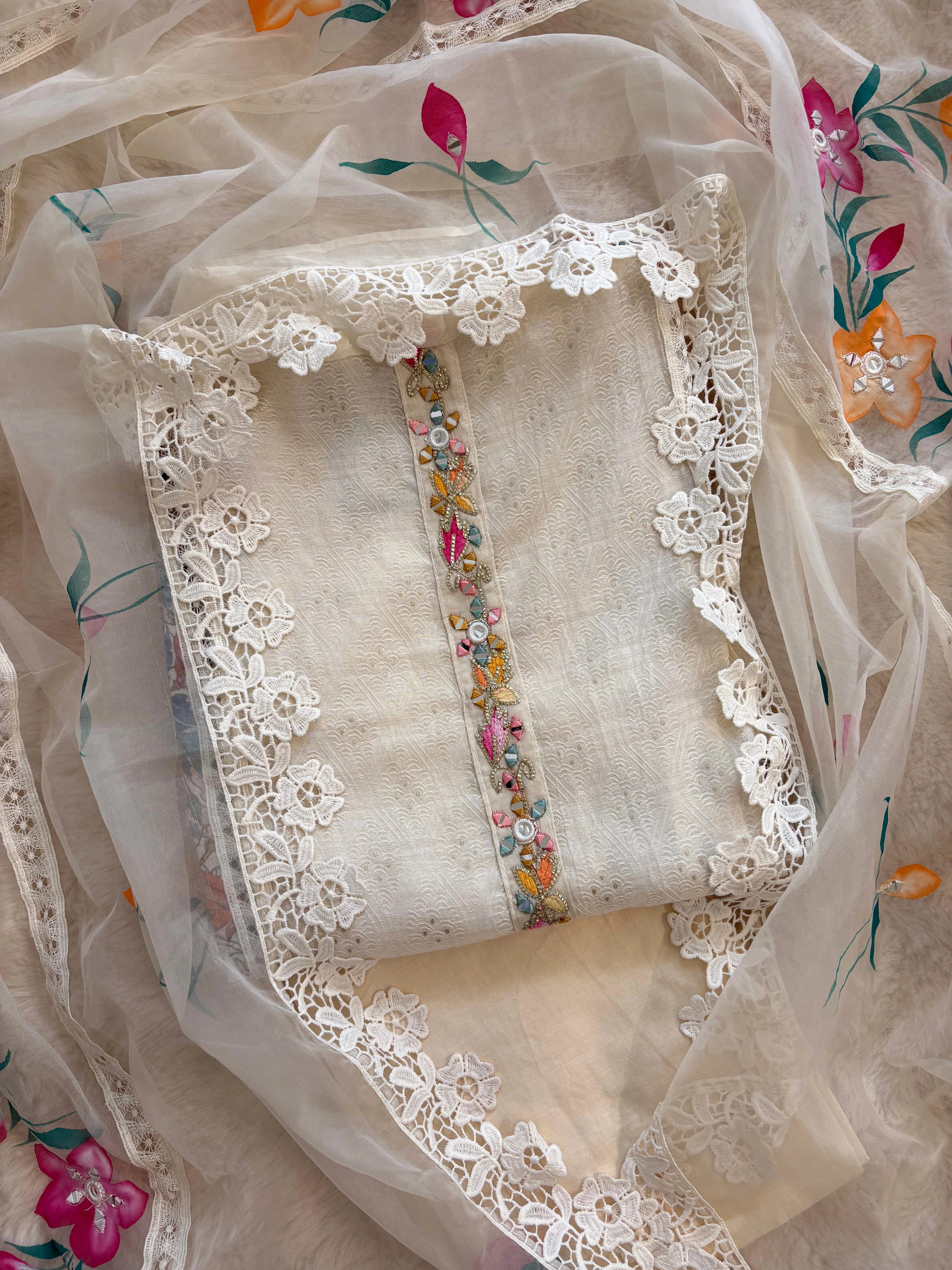 Ivory linen suit with embroidered detailing and hand-painted floral organza dupatta, finished with lace border – unstitched ethnic wear set