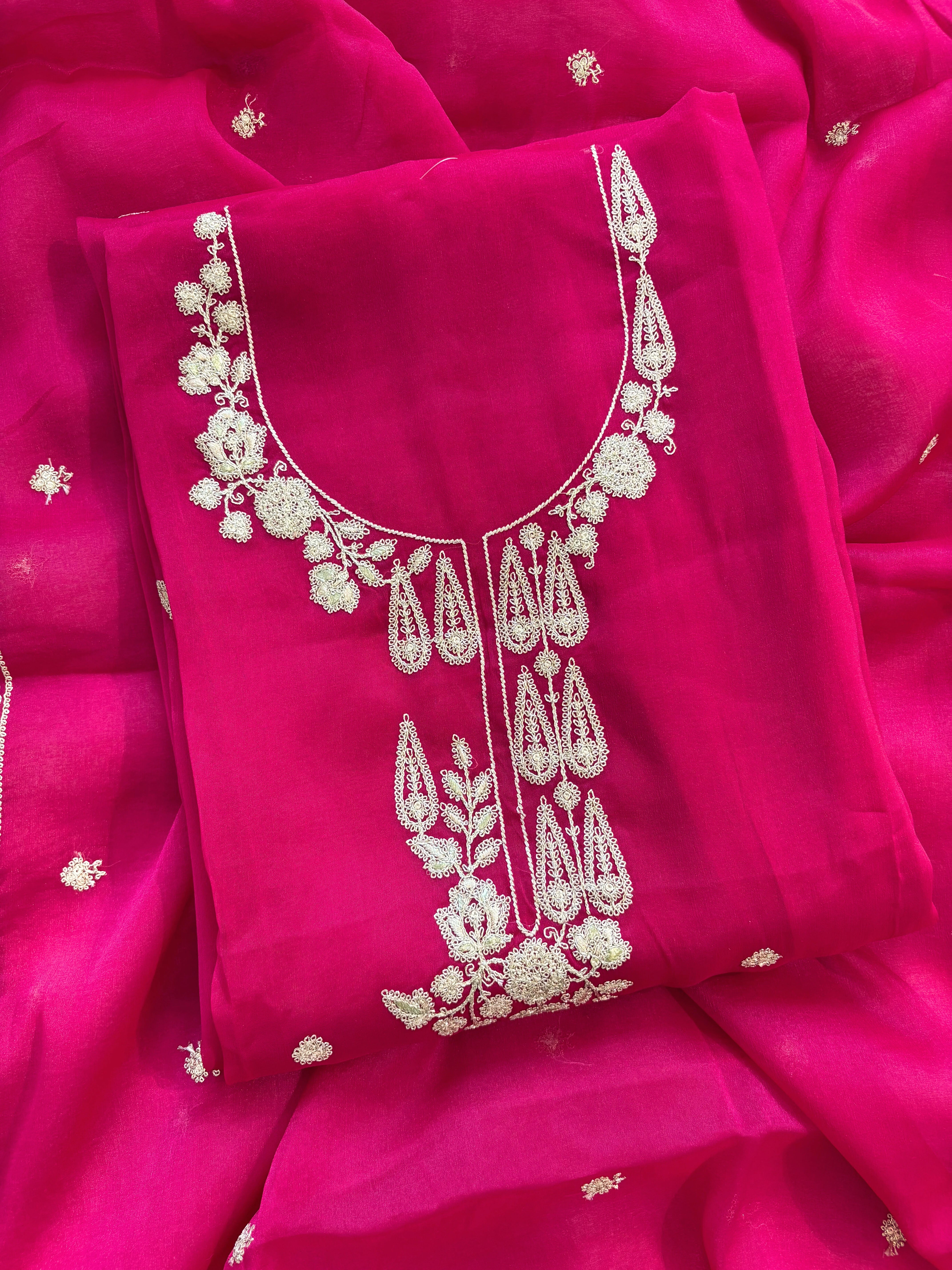 Hot pink organza unstitched suit with golden zari embroidery and embroidered dupatta, ideal for weddings and festive celebrations.