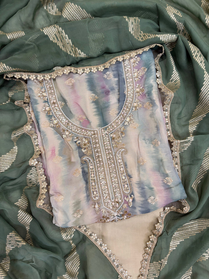 Pastel green organza suit with gold zari embroidery, pearl embellishments, and sequin work, paired with an banarisi jacquard dupatta for weddings and festive occasions.