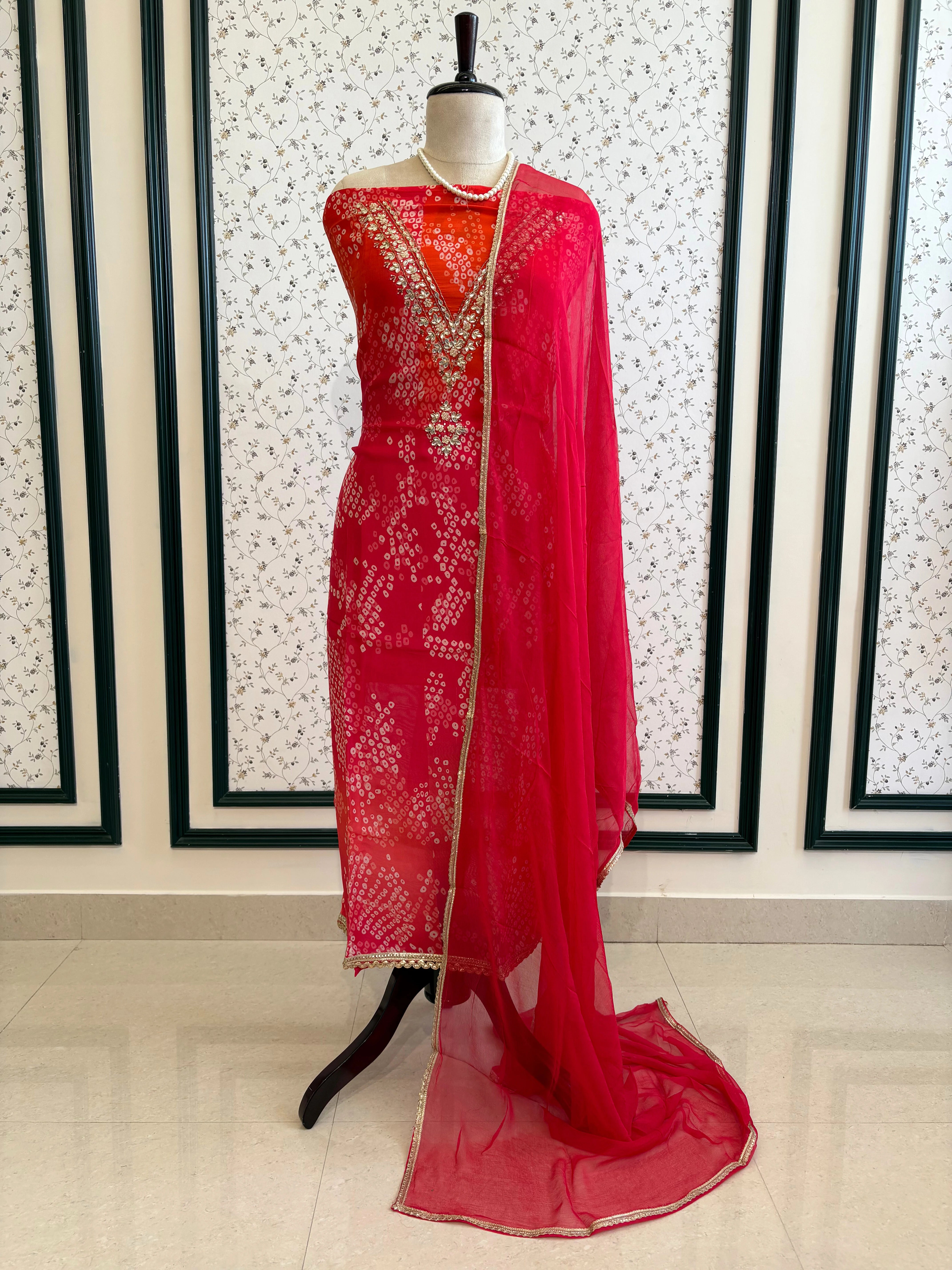 Red organza bandhani suit with ombre effect and chiffon dupatta with lace border.