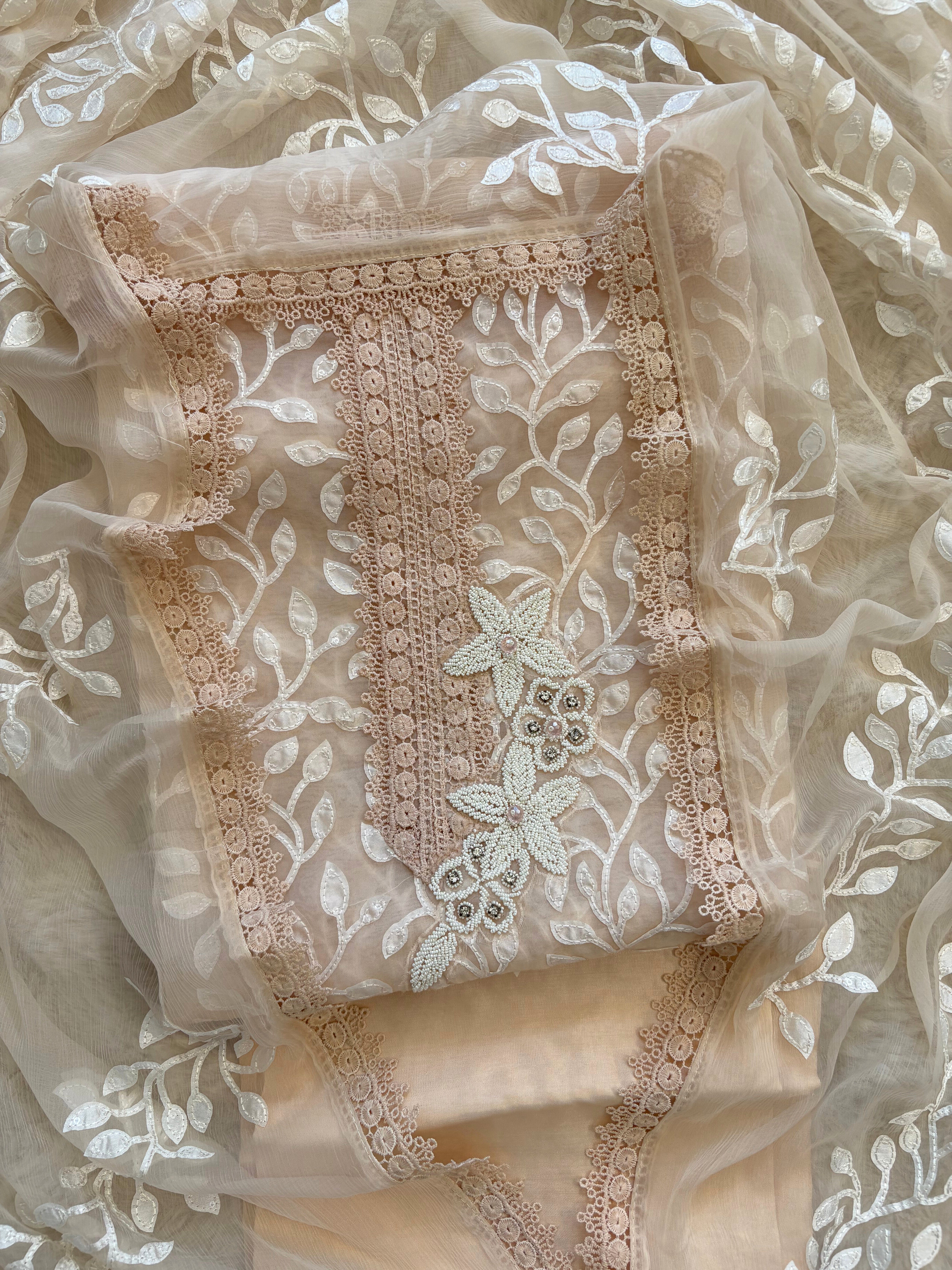 Peach organza suit with applique embroidery and moti bead embellishments, paired with embroidered organza dupatta.