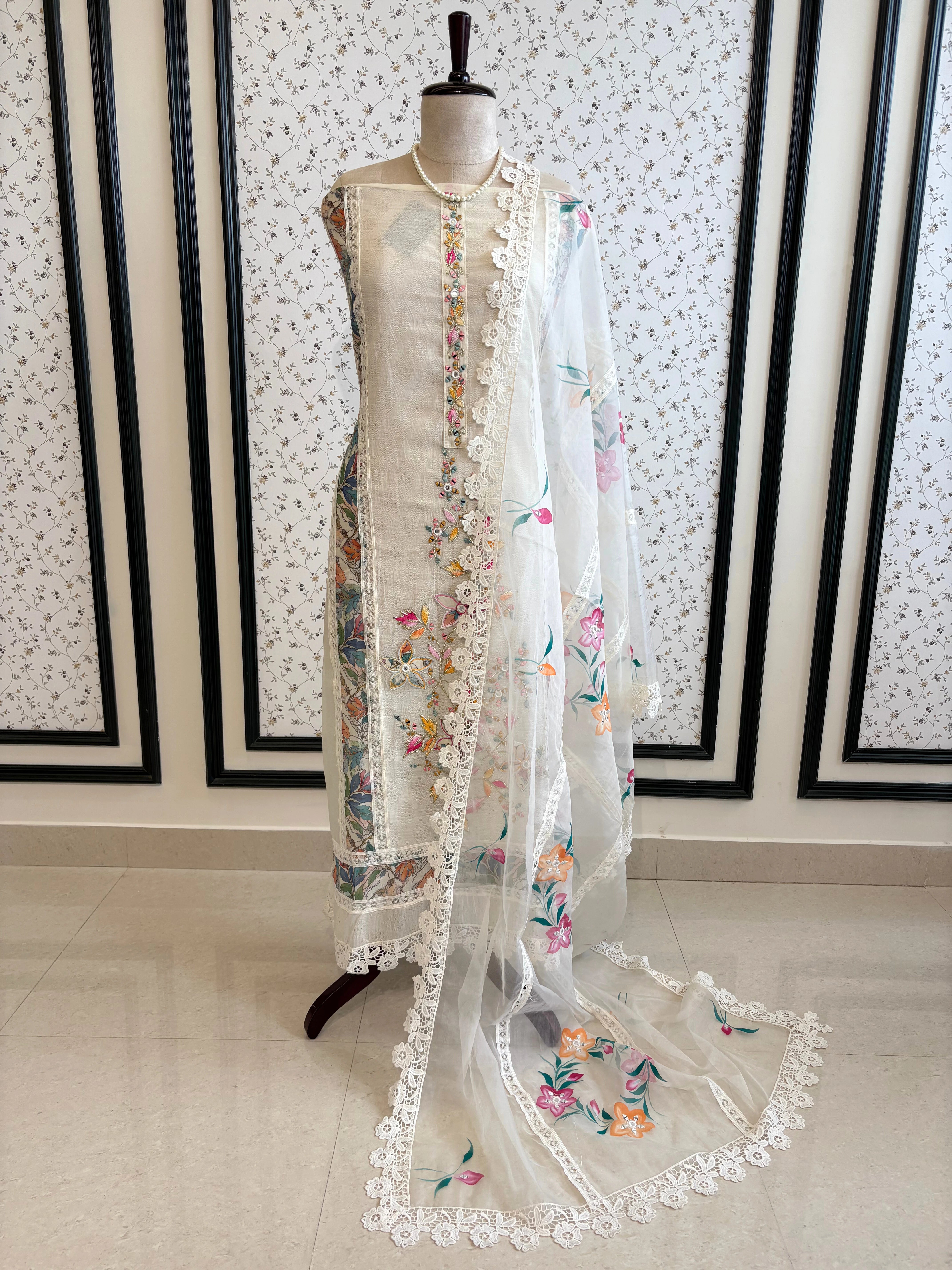 Ivory linen suit with embroidered detailing and hand-painted floral organza dupatta, finished with lace border – unstitched ethnic wear set