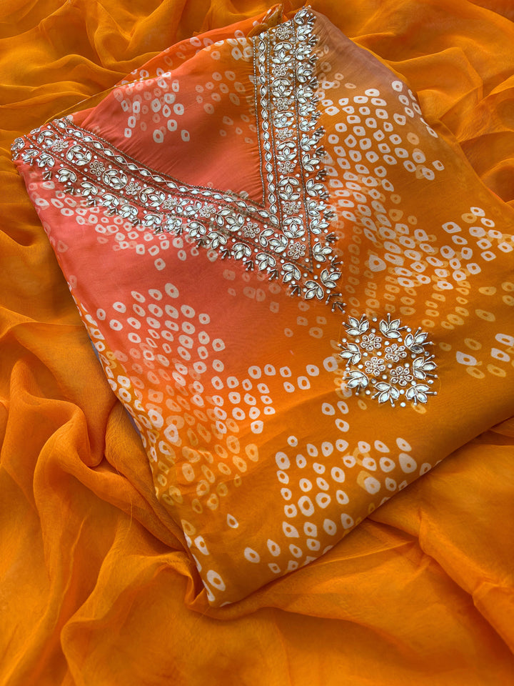 Orange organza bandhani suit with ombre effect and chiffon dupatta with lace border.