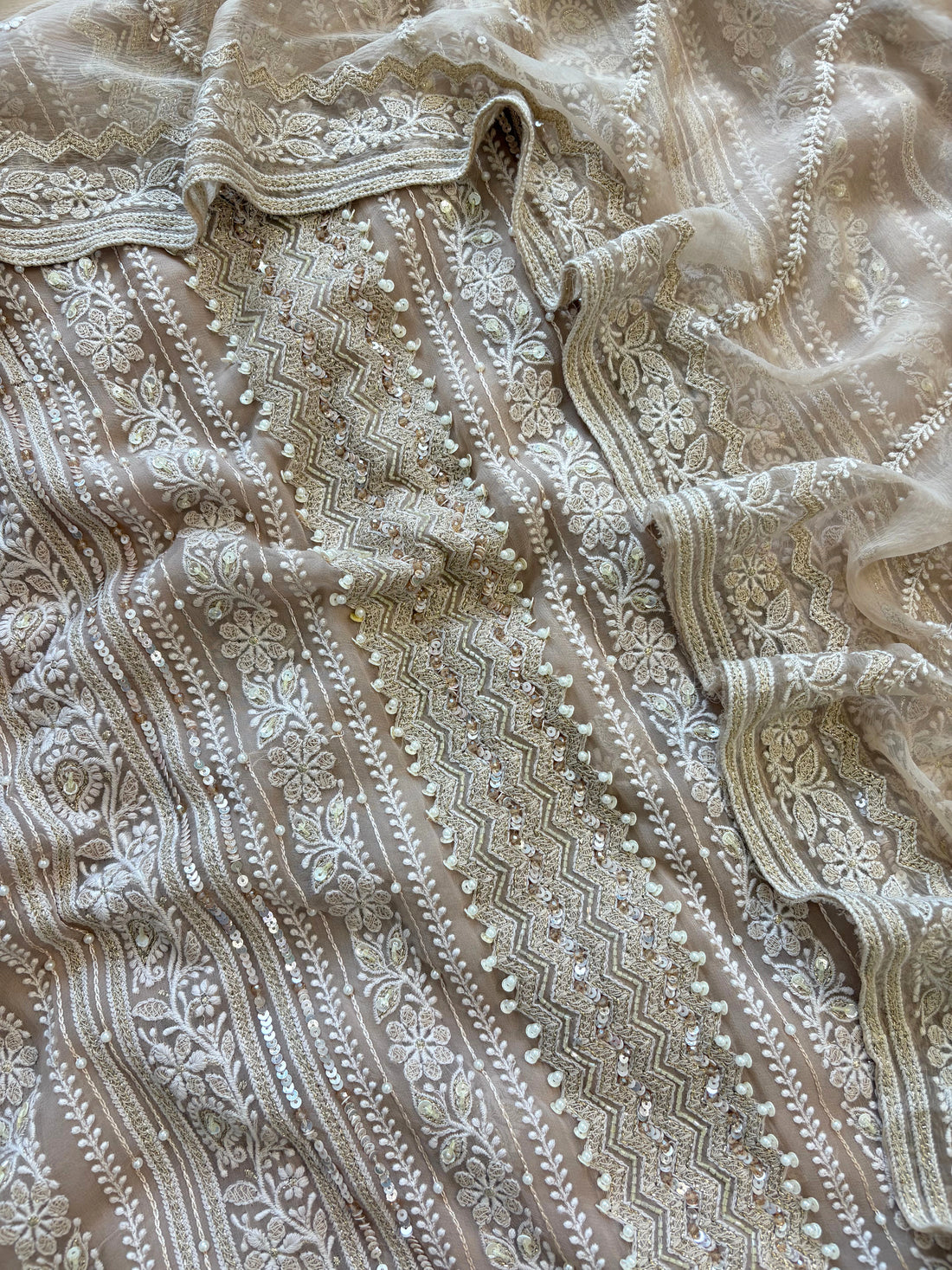 Nude georgette chikankari suit with moti and sequin highlighting, paired with chiffon chikankari dupatta.