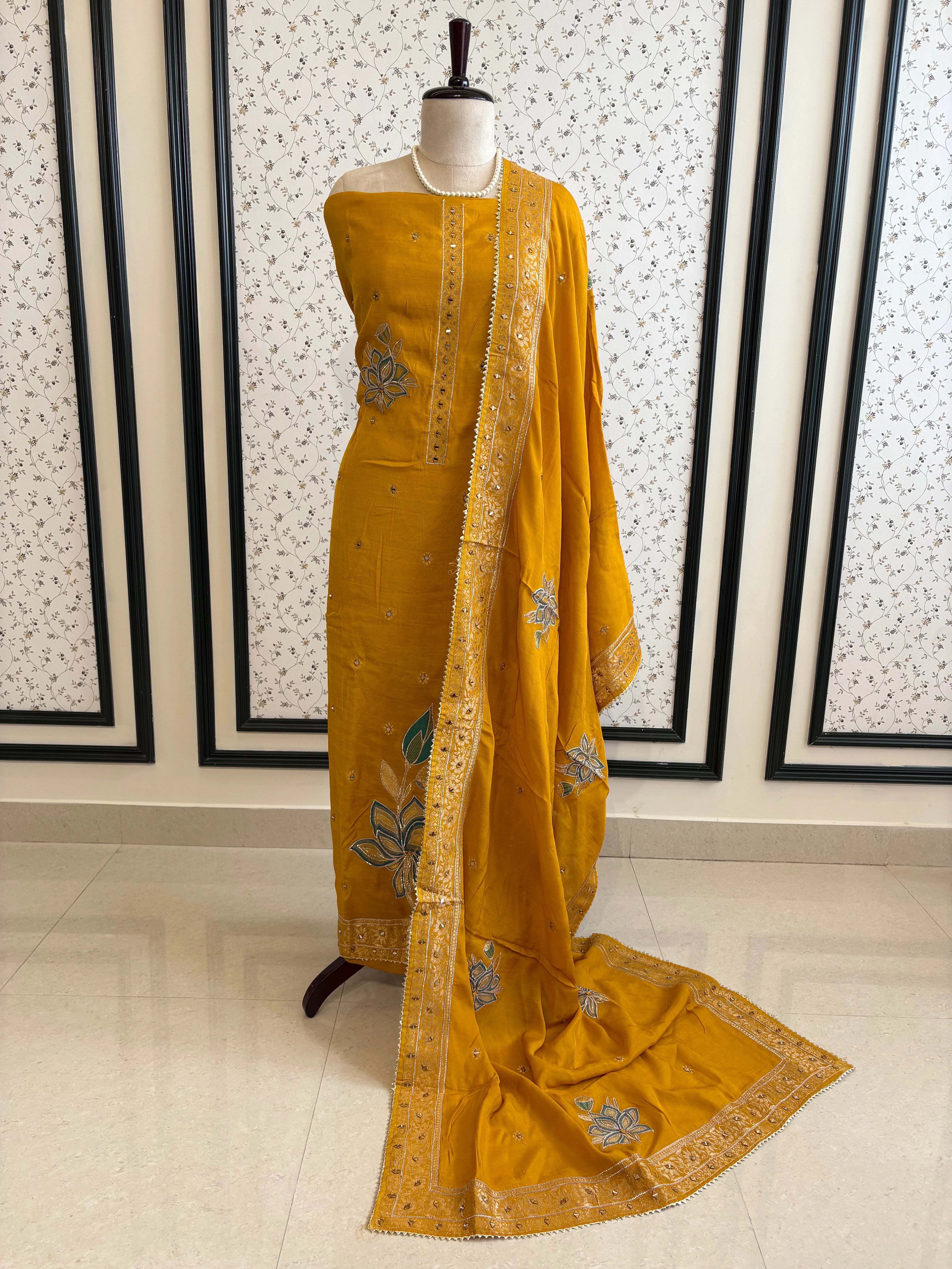 Mustard yellow linen suit with mirror work embroidery and applique floral dupatta.