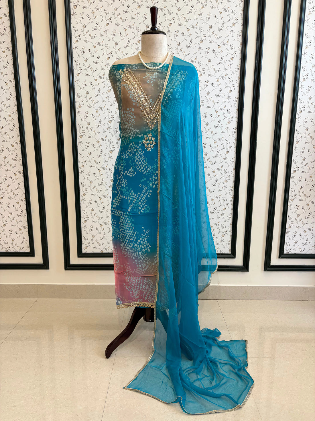 Blue organza bandhani suit with ombre effect and chiffon dupatta with lace border.