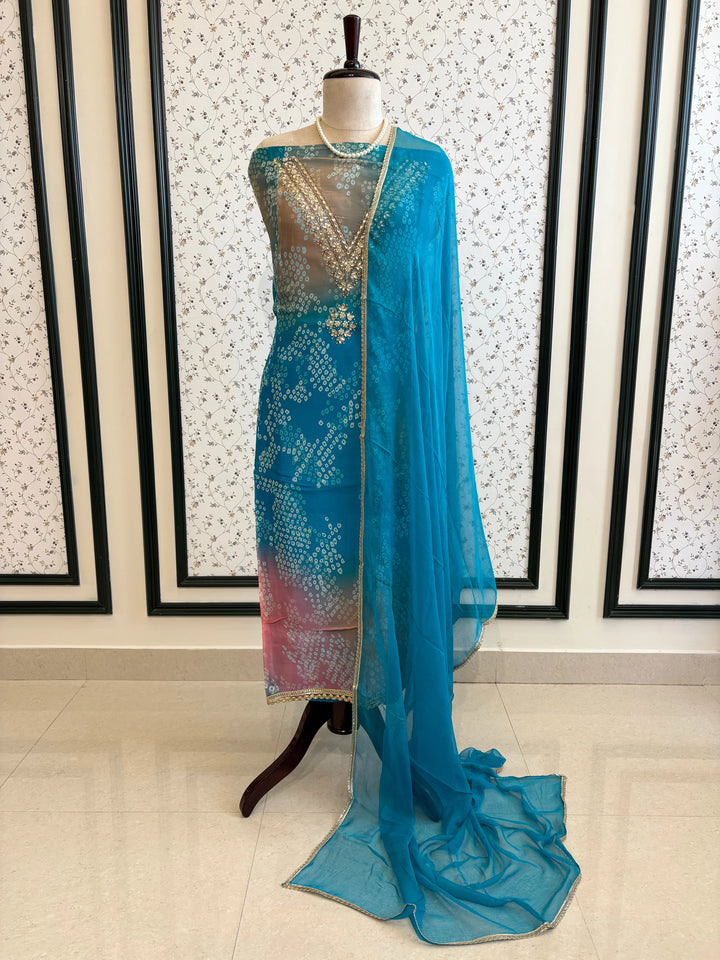 Blue organza bandhani suit with ombre effect and chiffon dupatta with lace border.