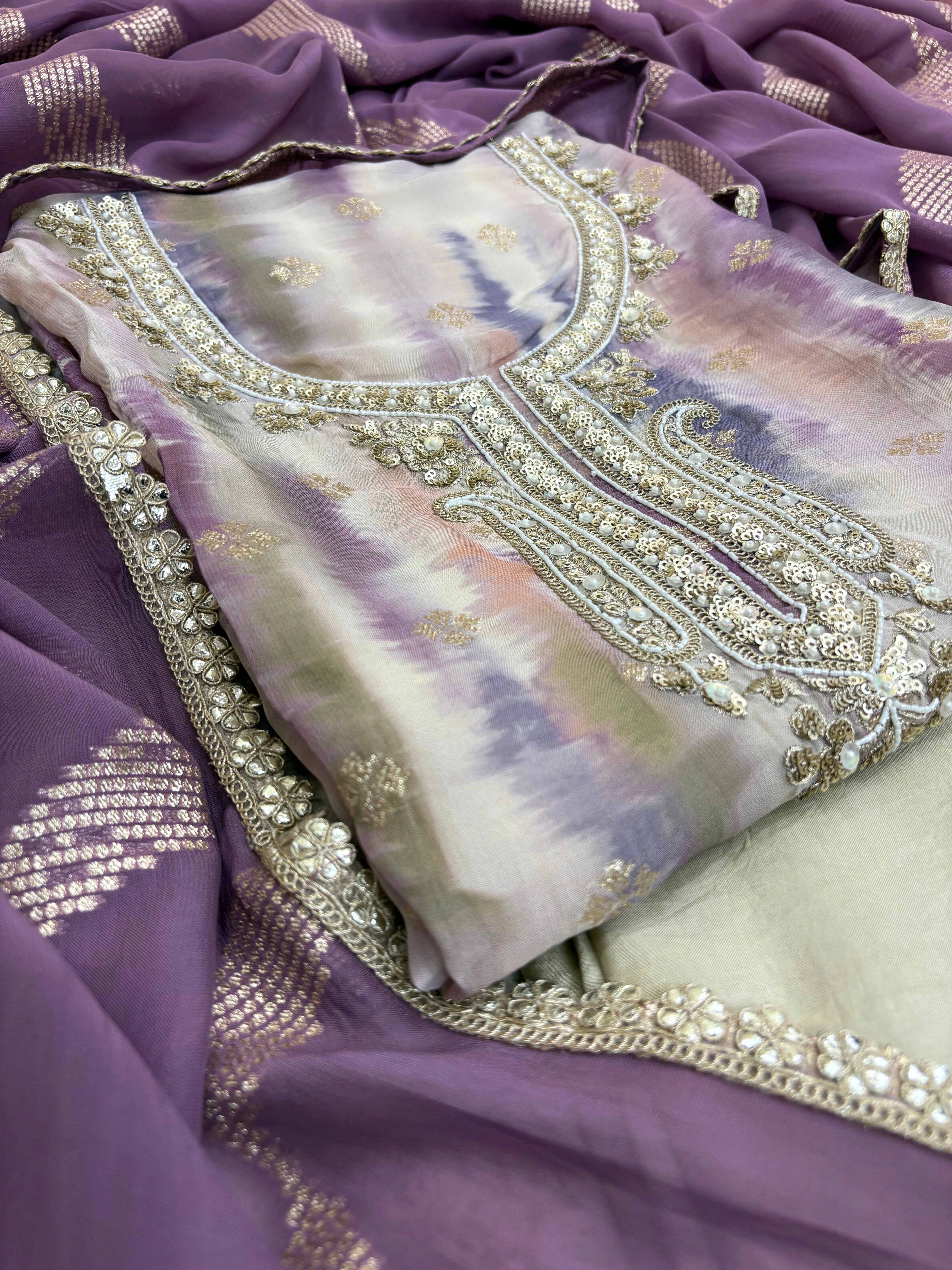 Pastel purple organza suit with silver zari embroidery, pearl embellishments, and sequin work, paired with an banarisi jacquard dupatta for weddings and festive occasions.