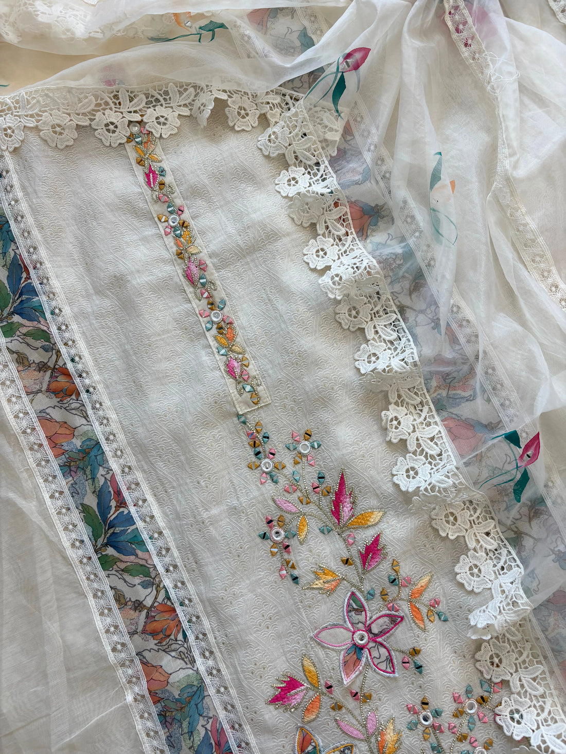 Ivory linen suit with embroidered detailing and hand-painted floral organza dupatta, finished with lace border – unstitched ethnic wear set
