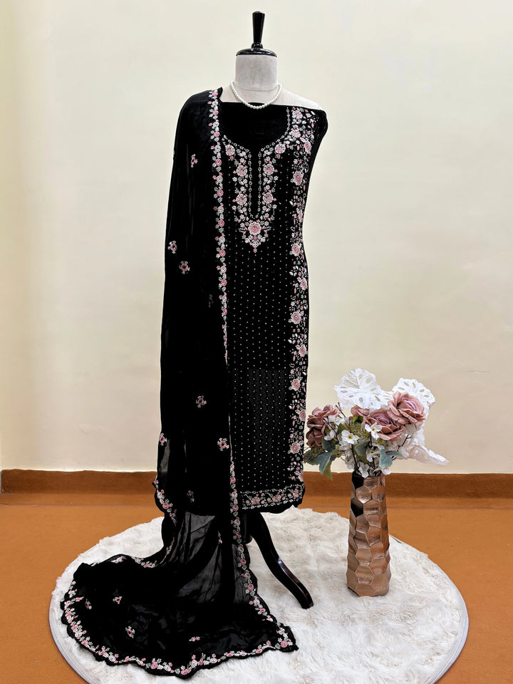Black chiffon suit with intricate pastel floral embroidery, sequin accents, and a matching embroidered dupatta, ideal for weddings and festive occasions.