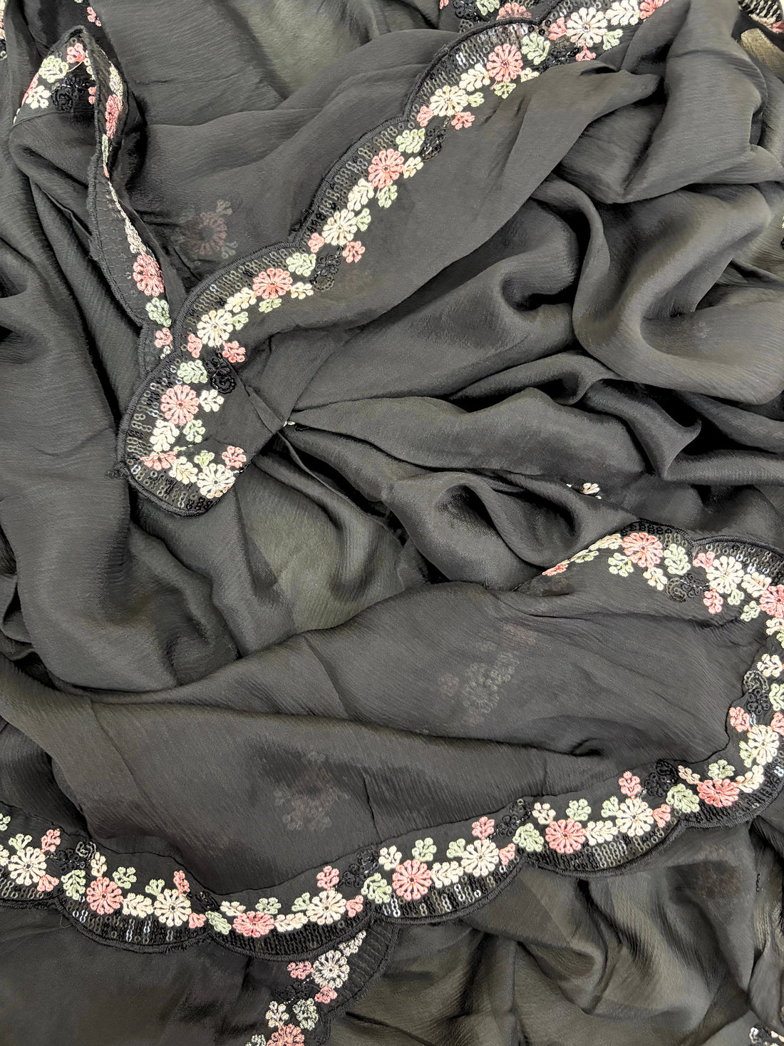 Black chiffon suit with intricate pastel floral embroidery, sequin accents, and a matching embroidered dupatta, ideal for weddings and festive occasions.