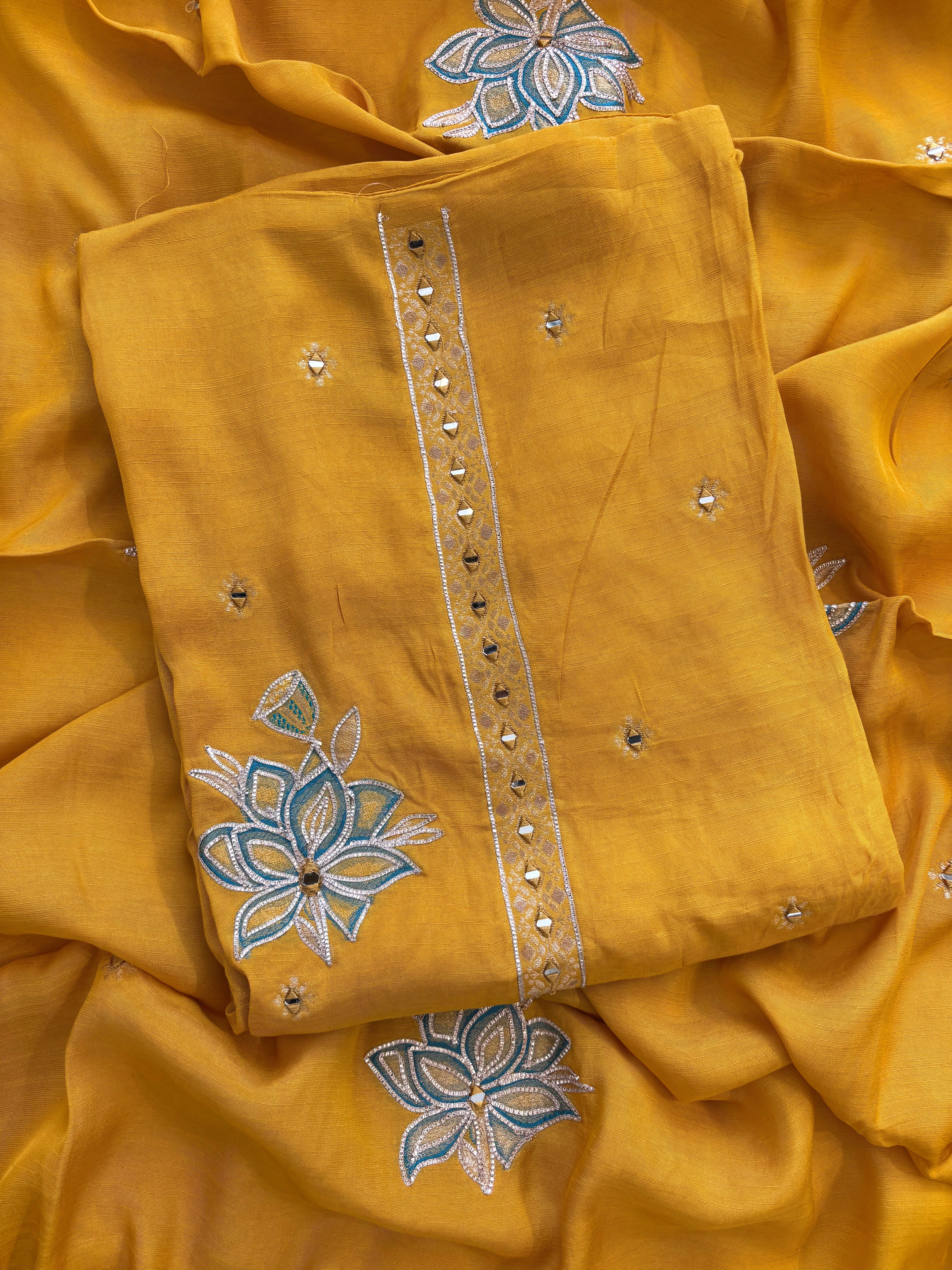 Mustard yellow linen suit with mirror work embroidery and applique floral dupatta.