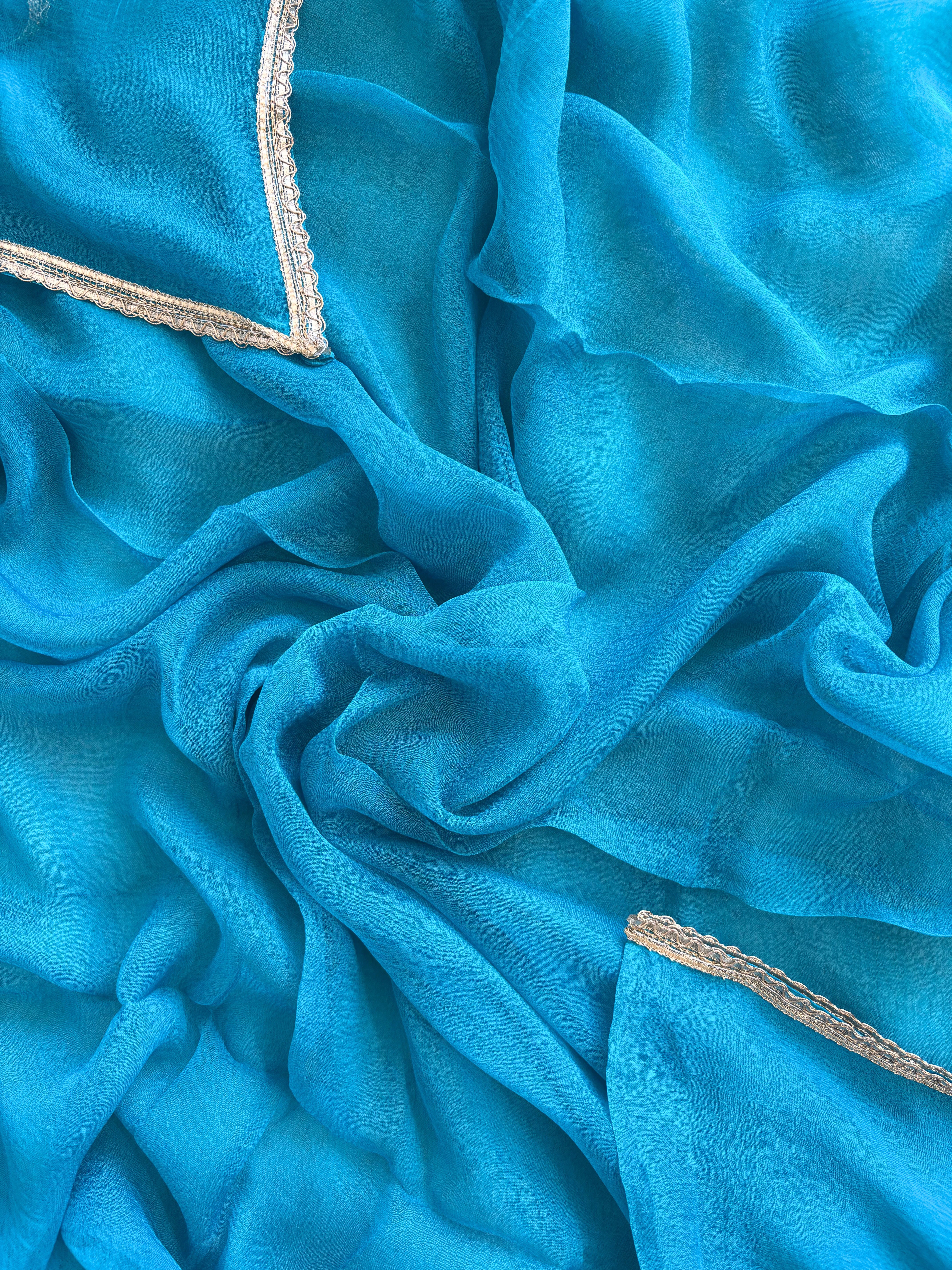 Blue organza bandhani suit with ombre effect and chiffon dupatta with lace border.