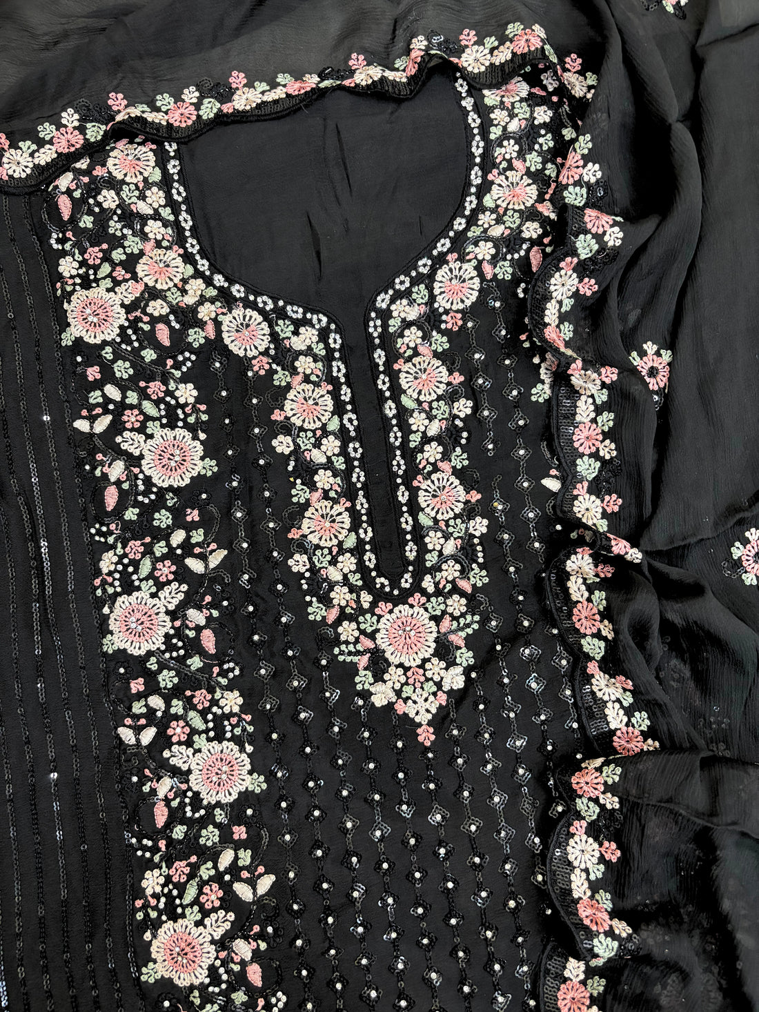 Black chiffon suit with intricate pastel floral embroidery, sequin accents, and a matching embroidered dupatta, ideal for weddings and festive occasions.
