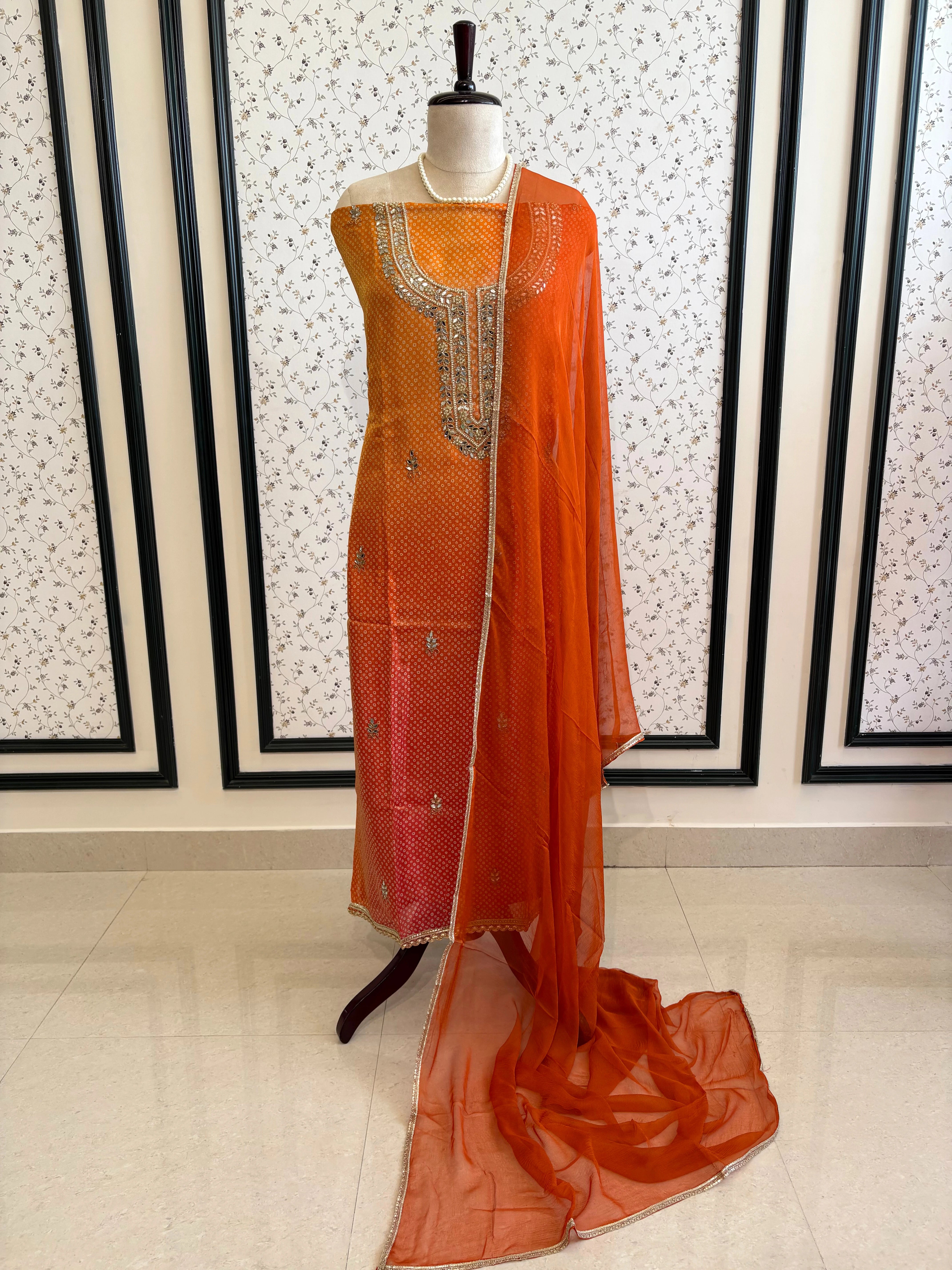 Orange Shimmer organza bandhani suit with ombre effect and chiffon dupatta with lace border.