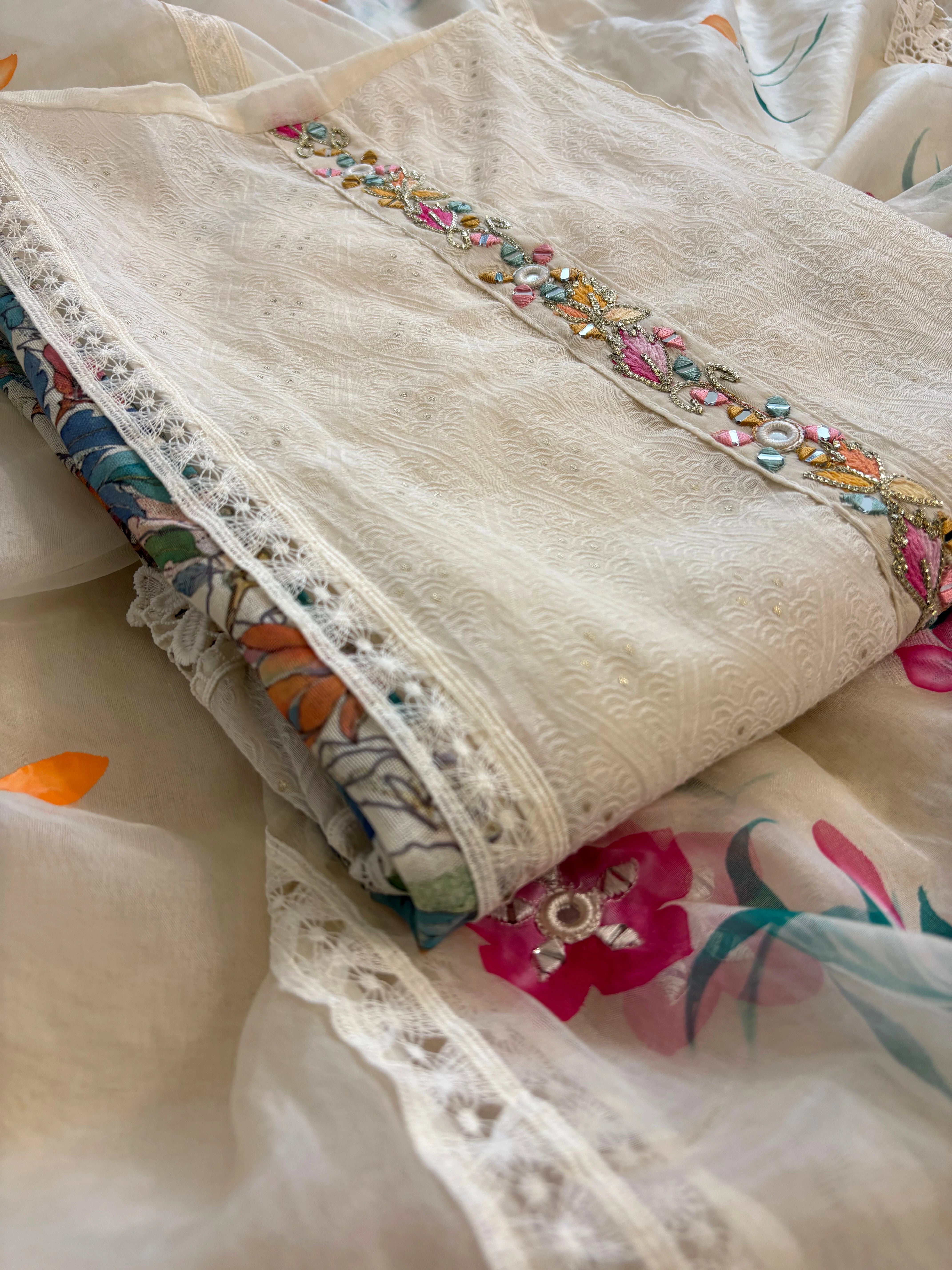 Ivory linen suit with embroidered detailing and hand-painted floral organza dupatta, finished with lace border – unstitched ethnic wear set