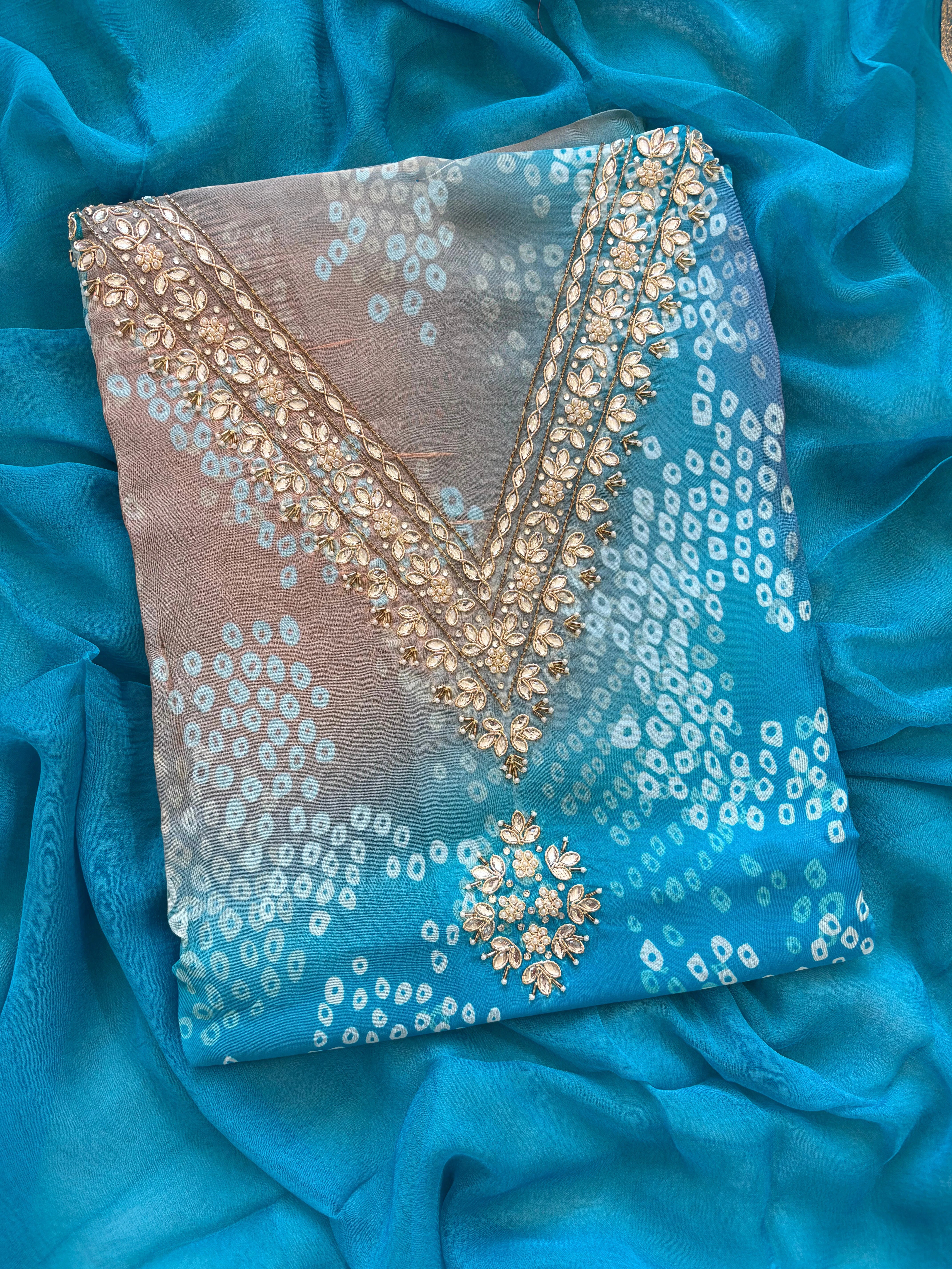 Blue organza bandhani suit with ombre effect and chiffon dupatta with lace border.