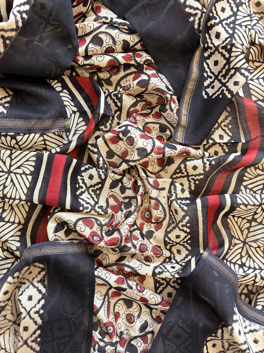 Maheshwari fabric suit with Kalamkari floral print in green, ivory, and maroon tones, featuring traditional hand-block designs and striped dupatta.