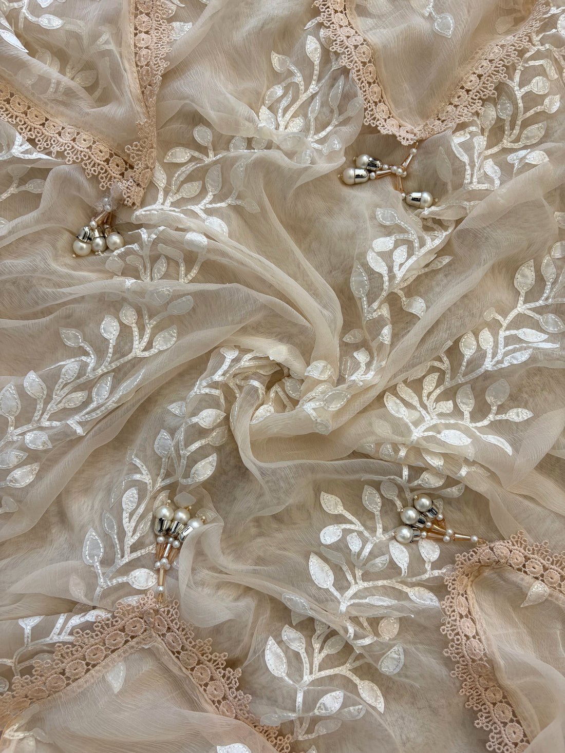 Peach organza suit with applique embroidery and moti bead embellishments, paired with embroidered organza dupatta.
