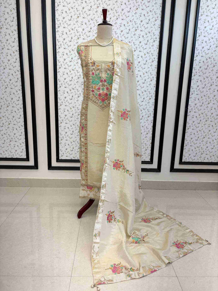 Ivory shimmer tissue unstitched suit displayed on mannequin with multicolour thread embroidery – The Zareesh