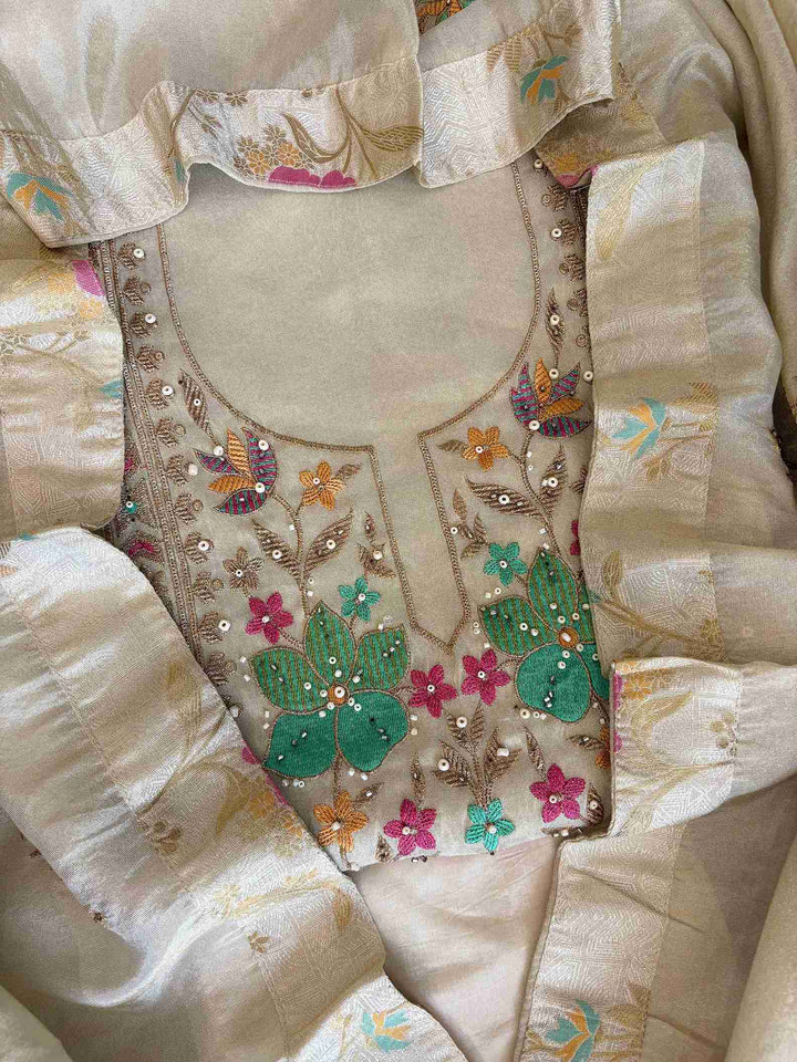 Luxury ivory shimmer tissue ethnic suit showcasing fine thread work and graceful drape