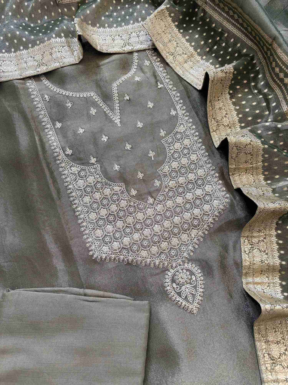 Zari-embroidered olive organza suit set with rich border dupatta on display