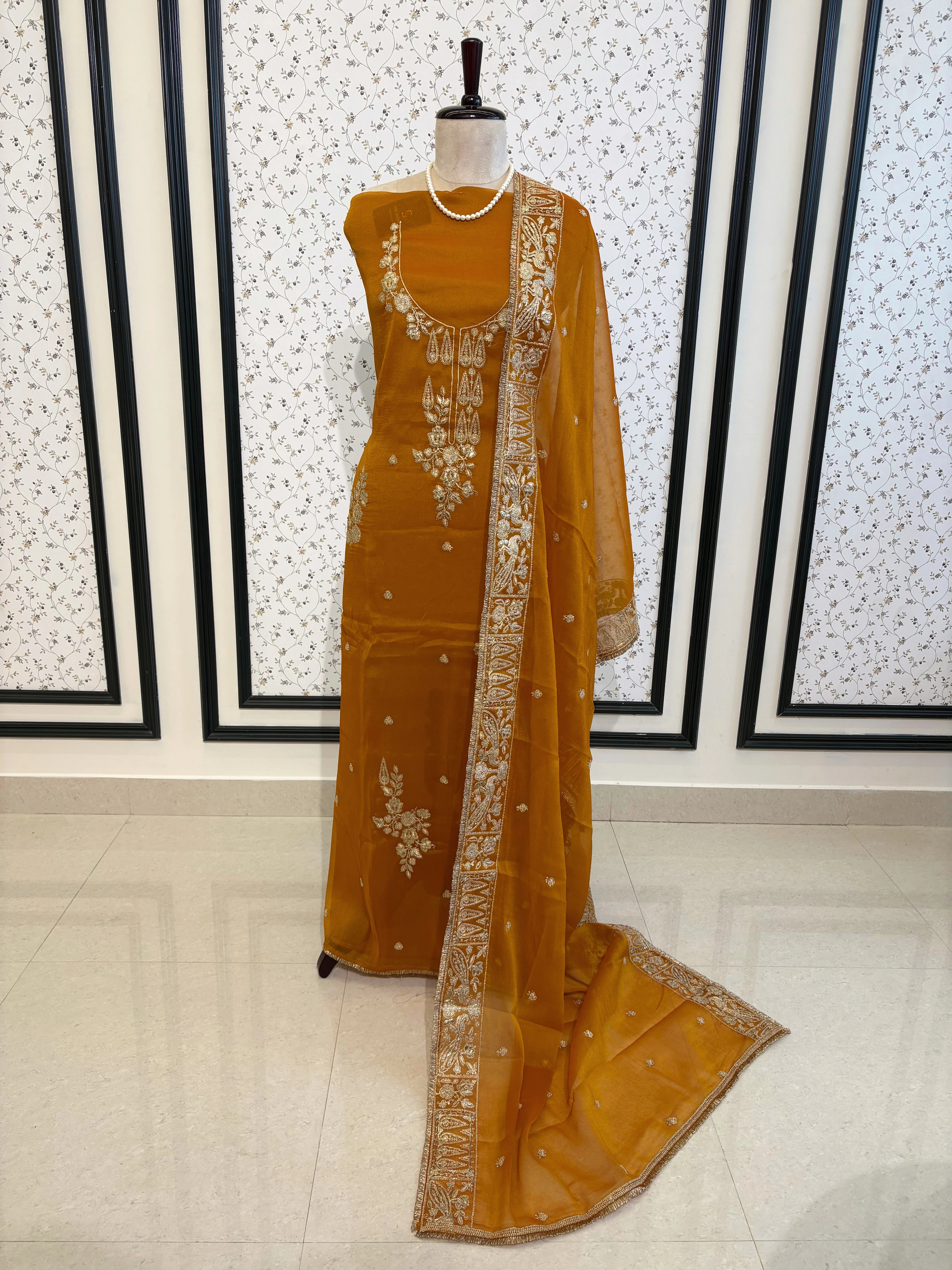 Mustard Yellow organza unstitched suit with golden zari embroidery and embroidered dupatta, ideal for weddings and festive celebrations.