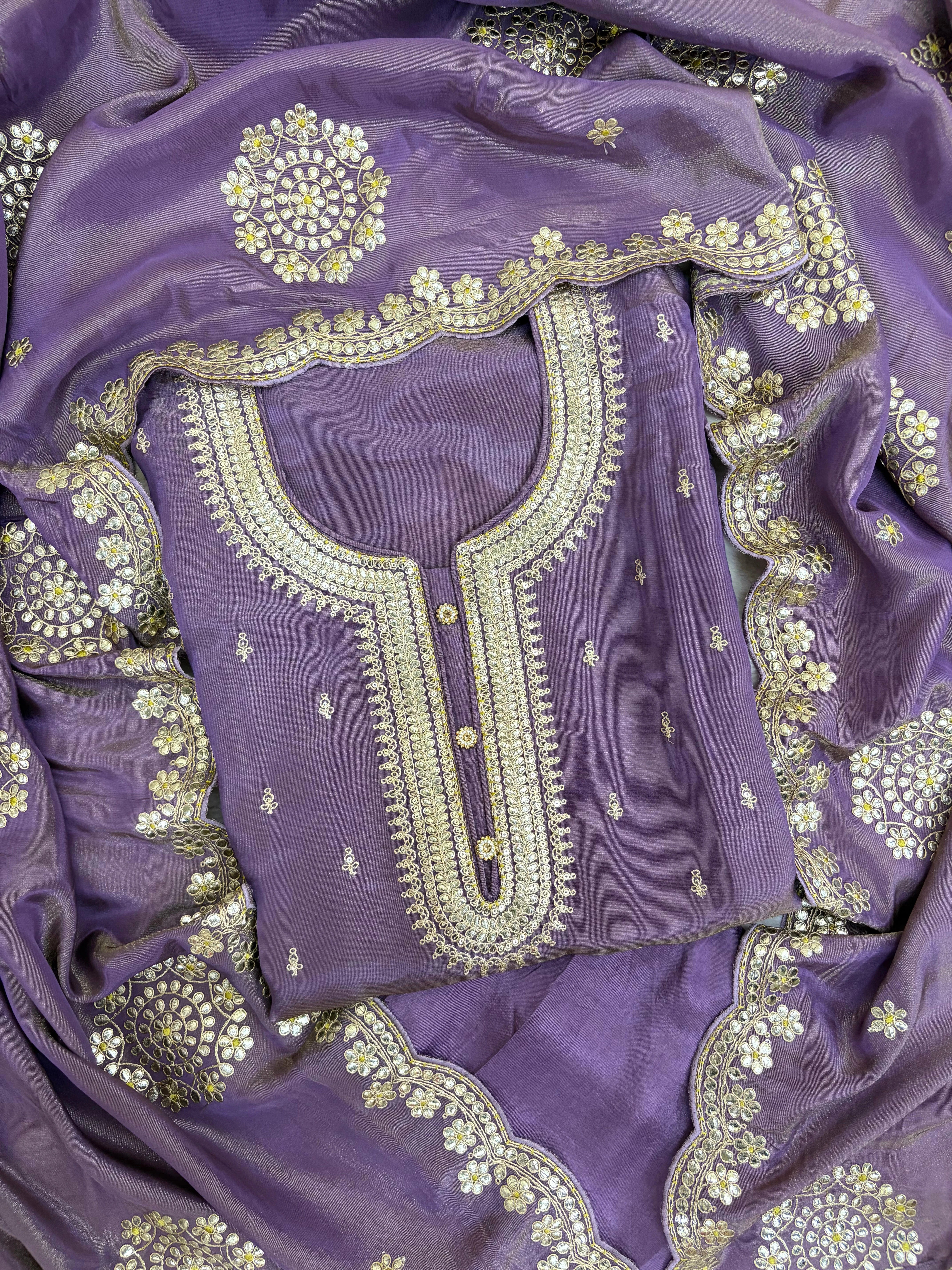 Royal purple silk unstitched suit with golden zari embroidery, sequins, floral motifs, and embroidered dupatta – perfect for weddings and festive wear