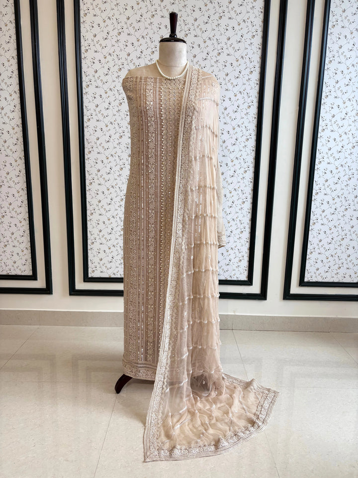 Nude georgette chikankari suit with moti and sequin highlighting, paired with chiffon chikankari dupatta.