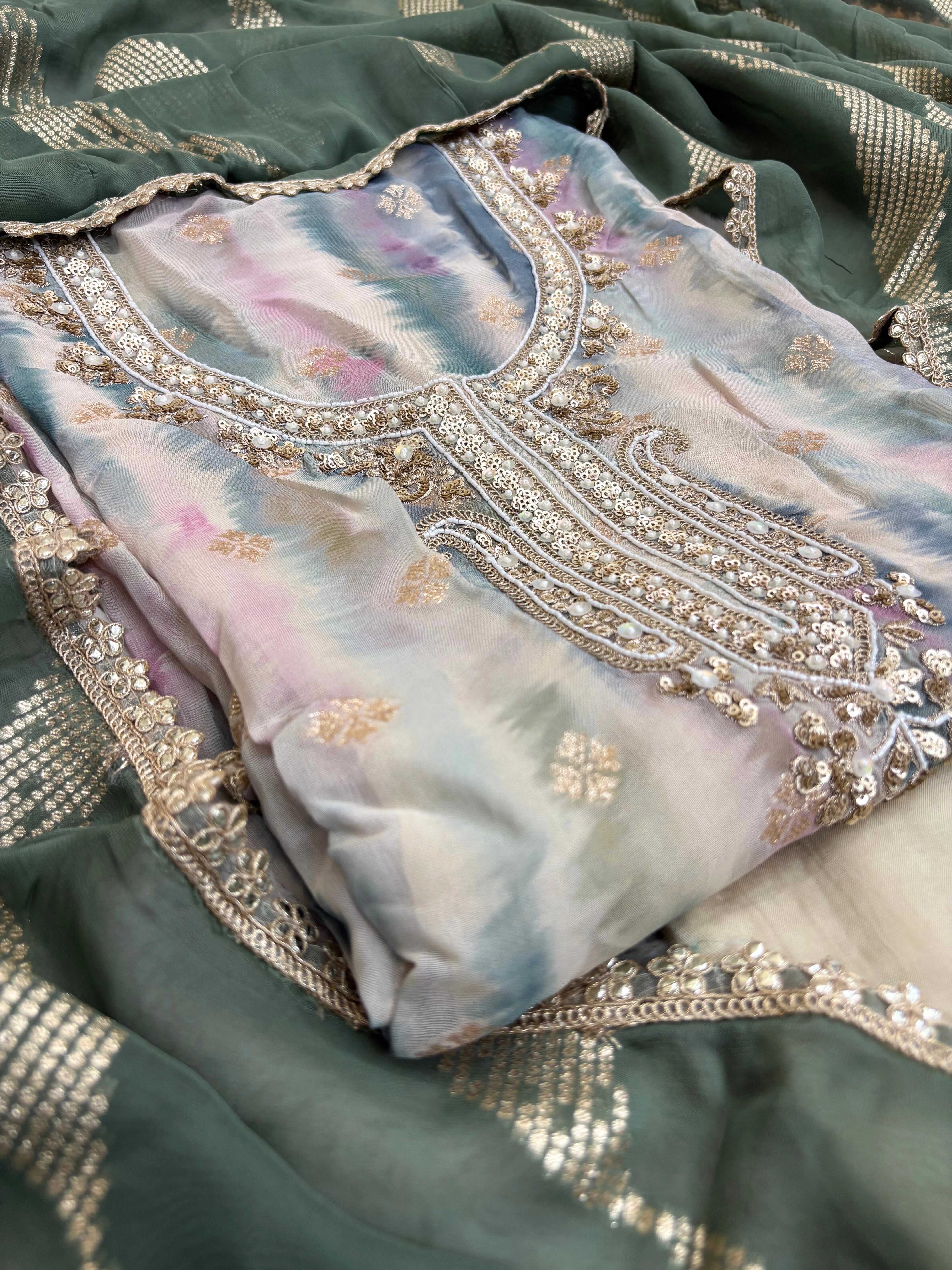 Pastel green organza suit with gold zari embroidery, pearl embellishments, and sequin work, paired with an banarisi jacquard dupatta for weddings and festive occasions.