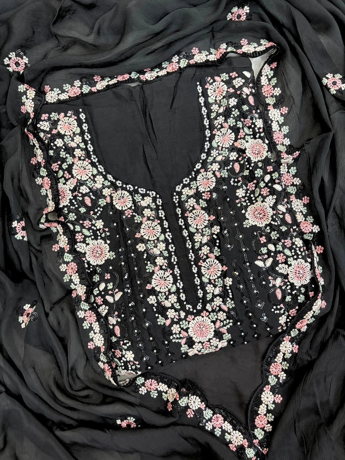 Black chiffon suit with intricate pastel floral embroidery, sequin accents, and a matching embroidered dupatta, ideal for weddings and festive occasions.