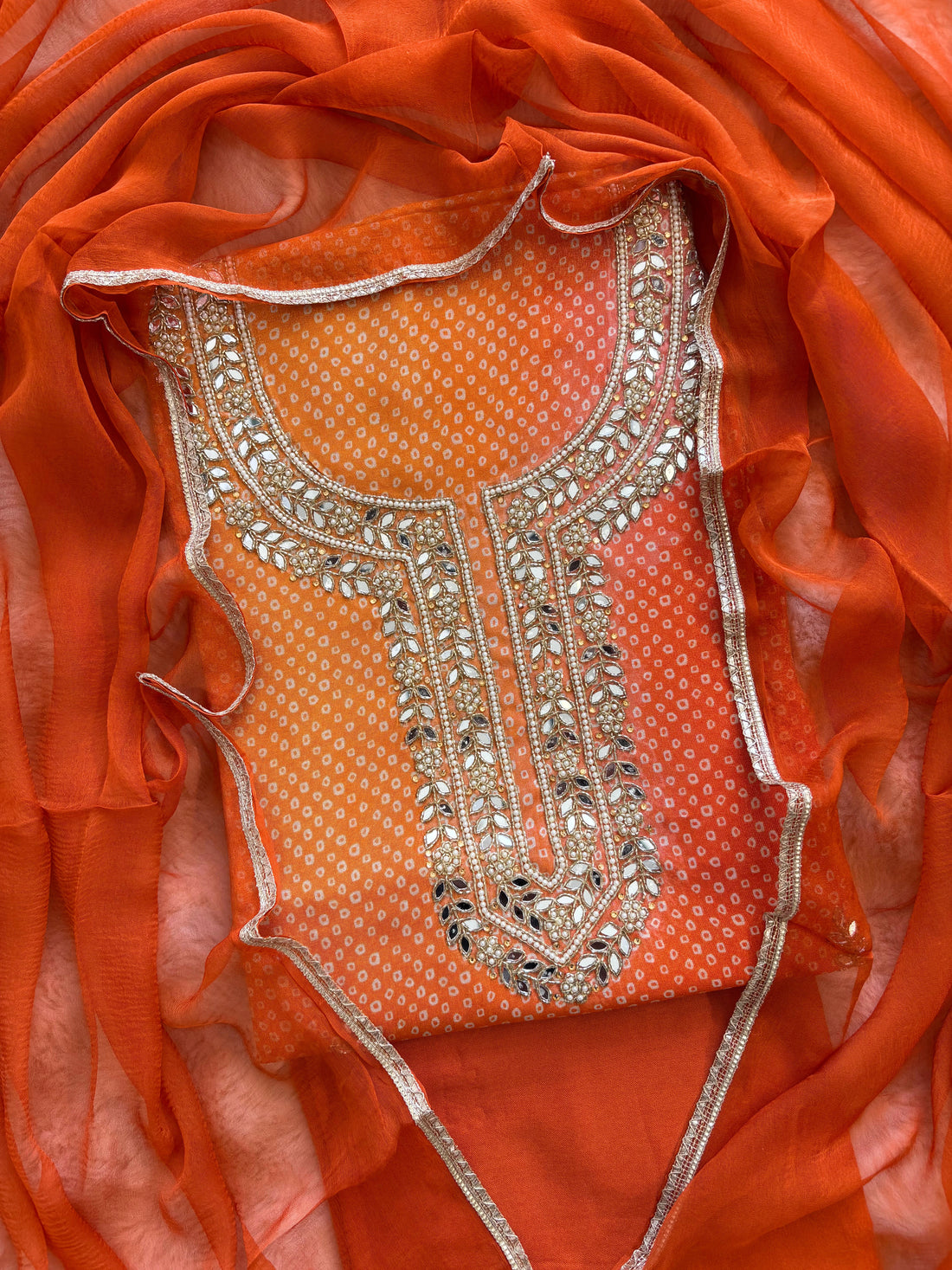 Orange Shimmer organza bandhani suit with ombre effect and chiffon dupatta with lace border.