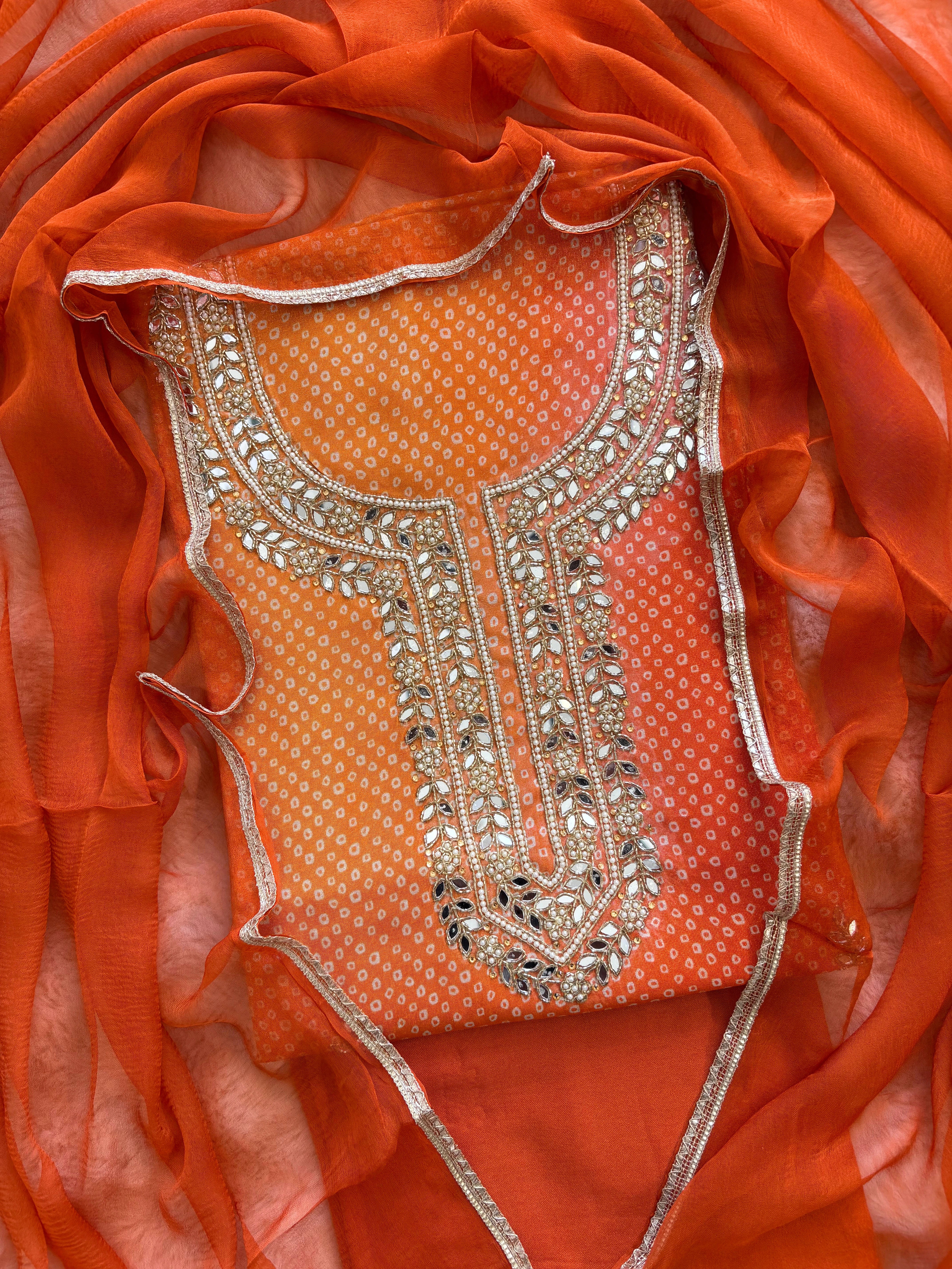 Orange Shimmer organza bandhani suit with ombre effect and chiffon dupatta with lace border.