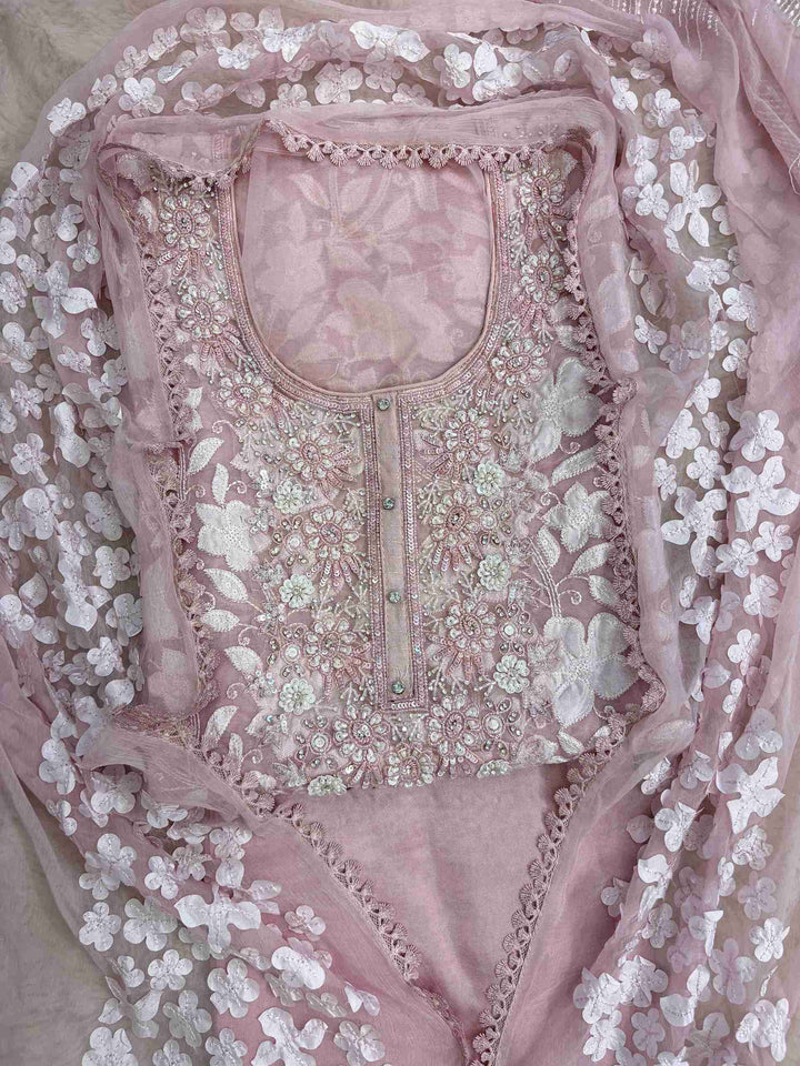 Close-up of all-over white floral applique work across the full body of baby pink organza shirt