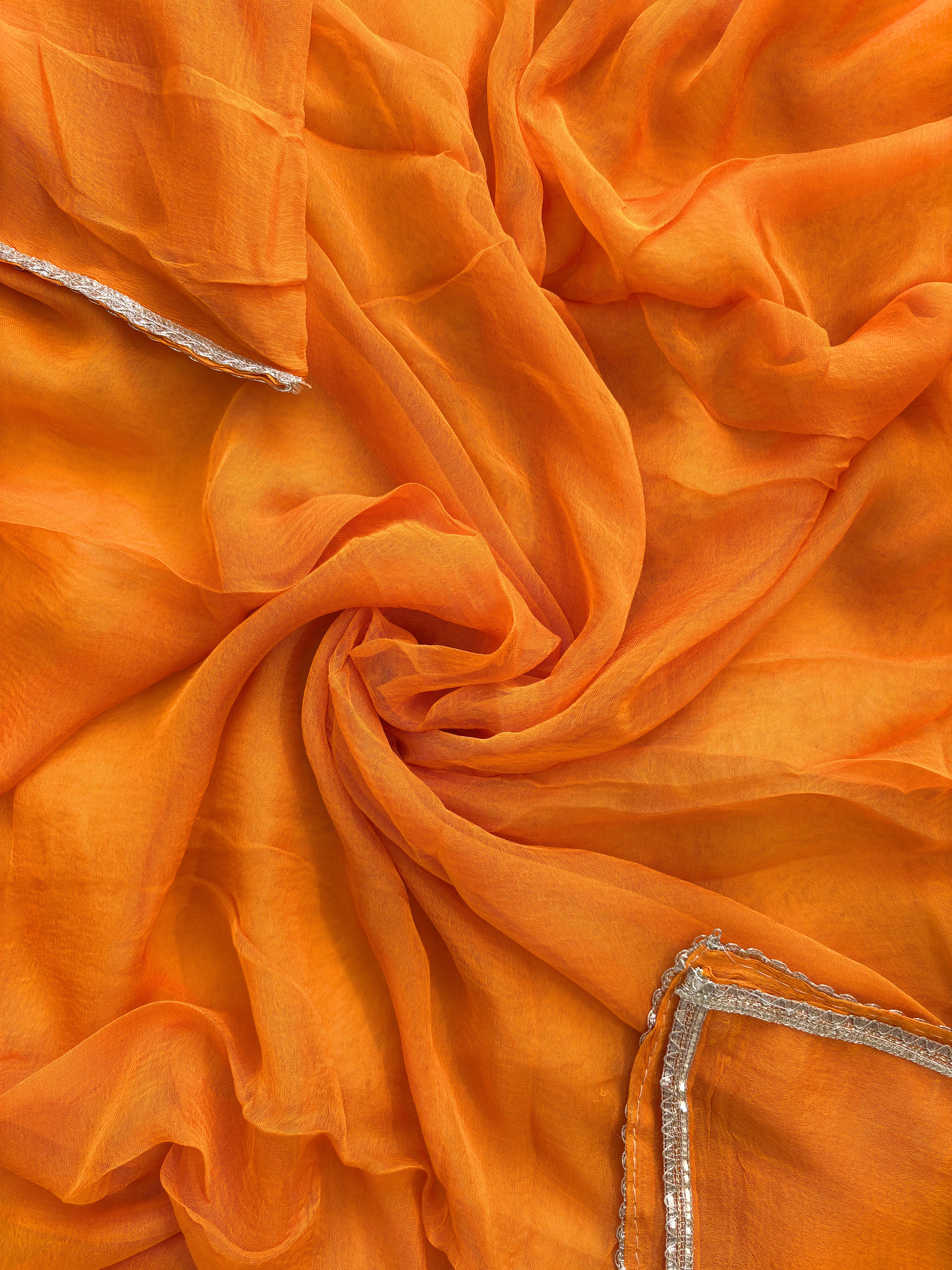 Orange organza bandhani suit with ombre effect and chiffon dupatta with lace border.