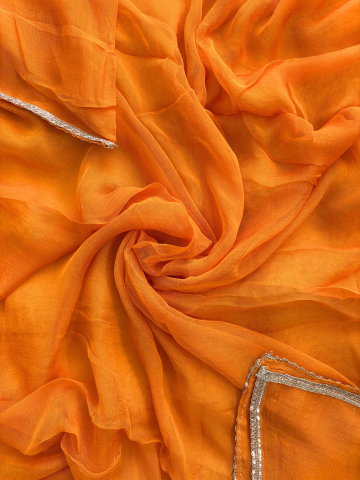 Orange organza bandhani suit with ombre effect and chiffon dupatta with lace border.