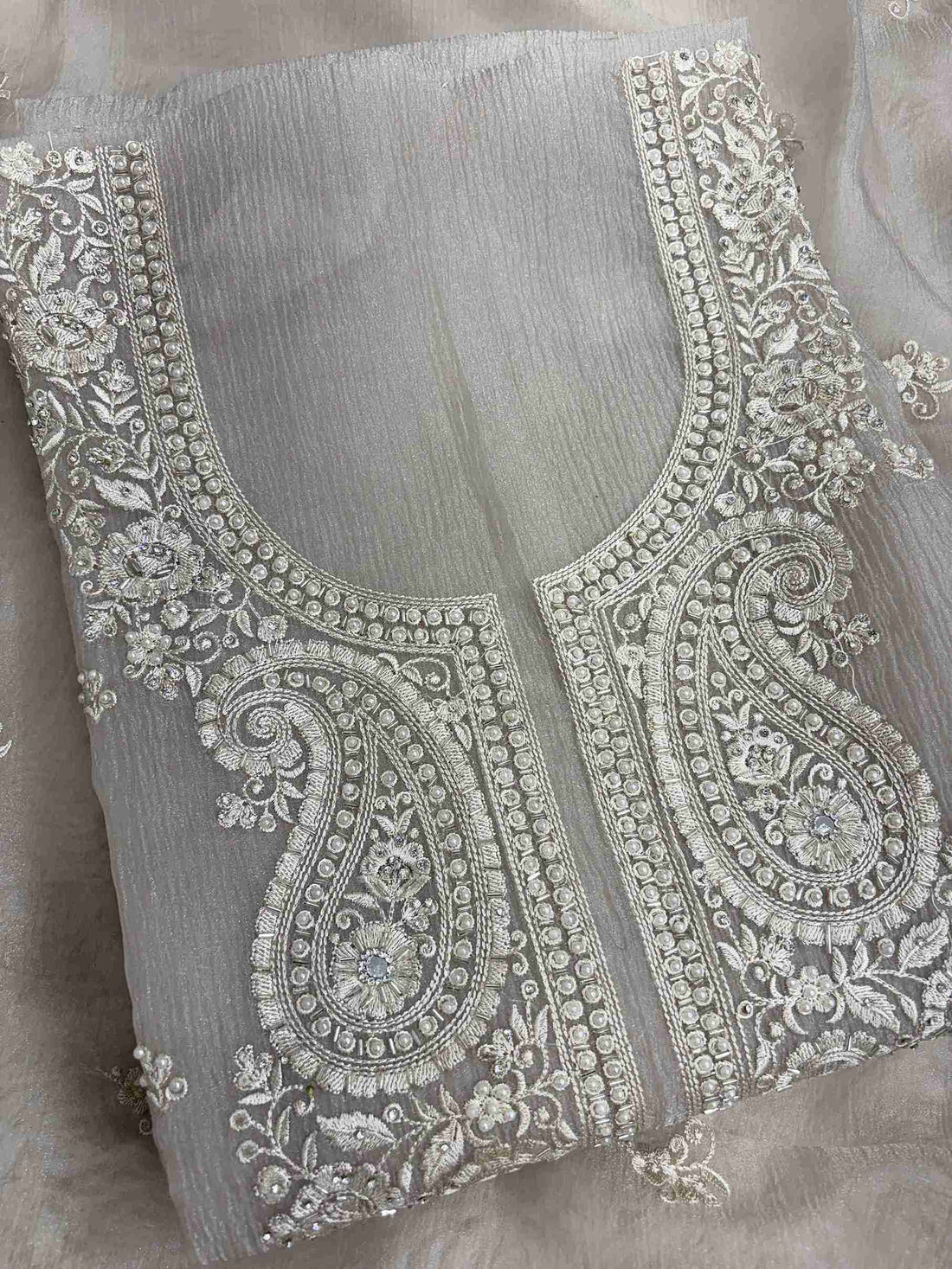 motifs detail across the neckline of beige marble chiffon shirt