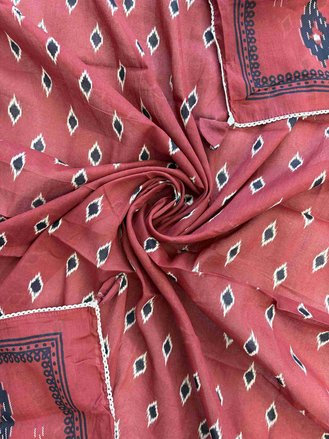 Matching ikat diamond print with coordinating printed borders and crotia lace edge on brick red cotton dupatta