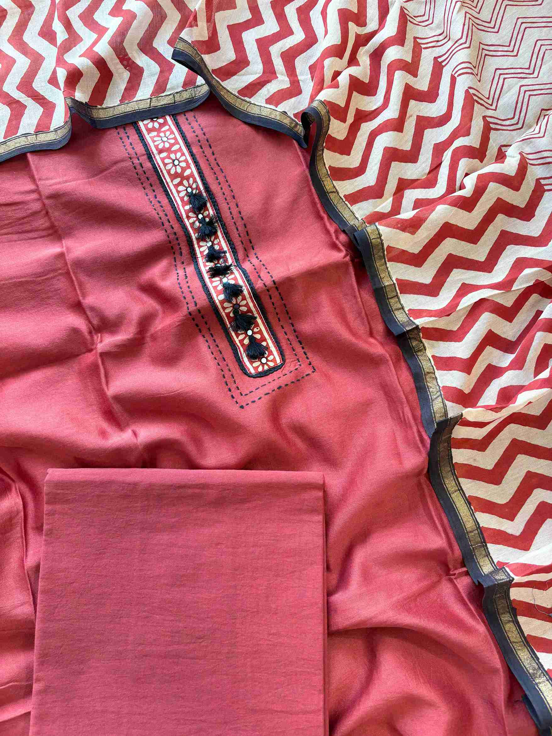 Close-up of printed floral placket neckline on brick red Maheshwari silk suit