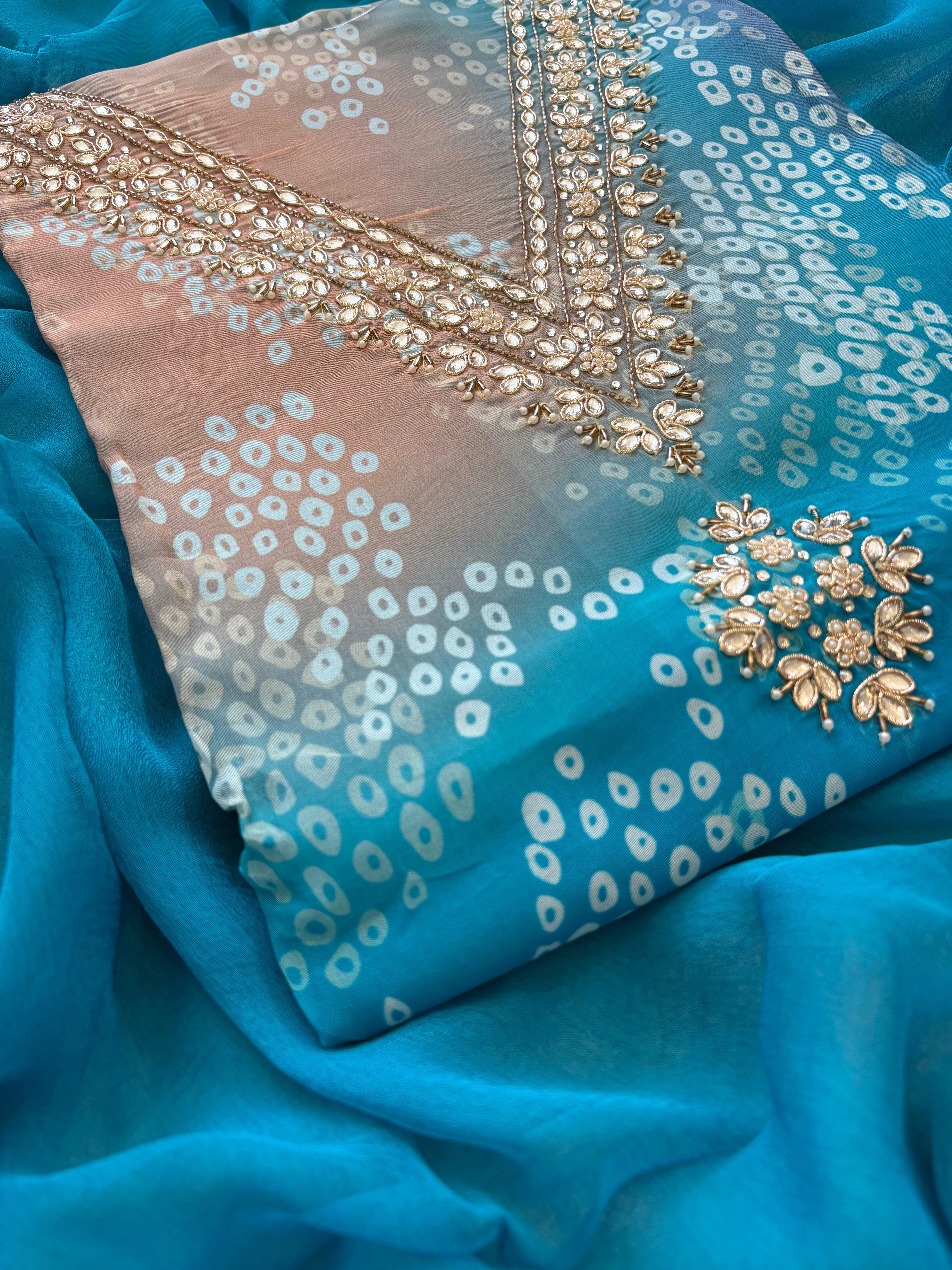 Blue organza bandhani suit with ombre effect and chiffon dupatta with lace border.