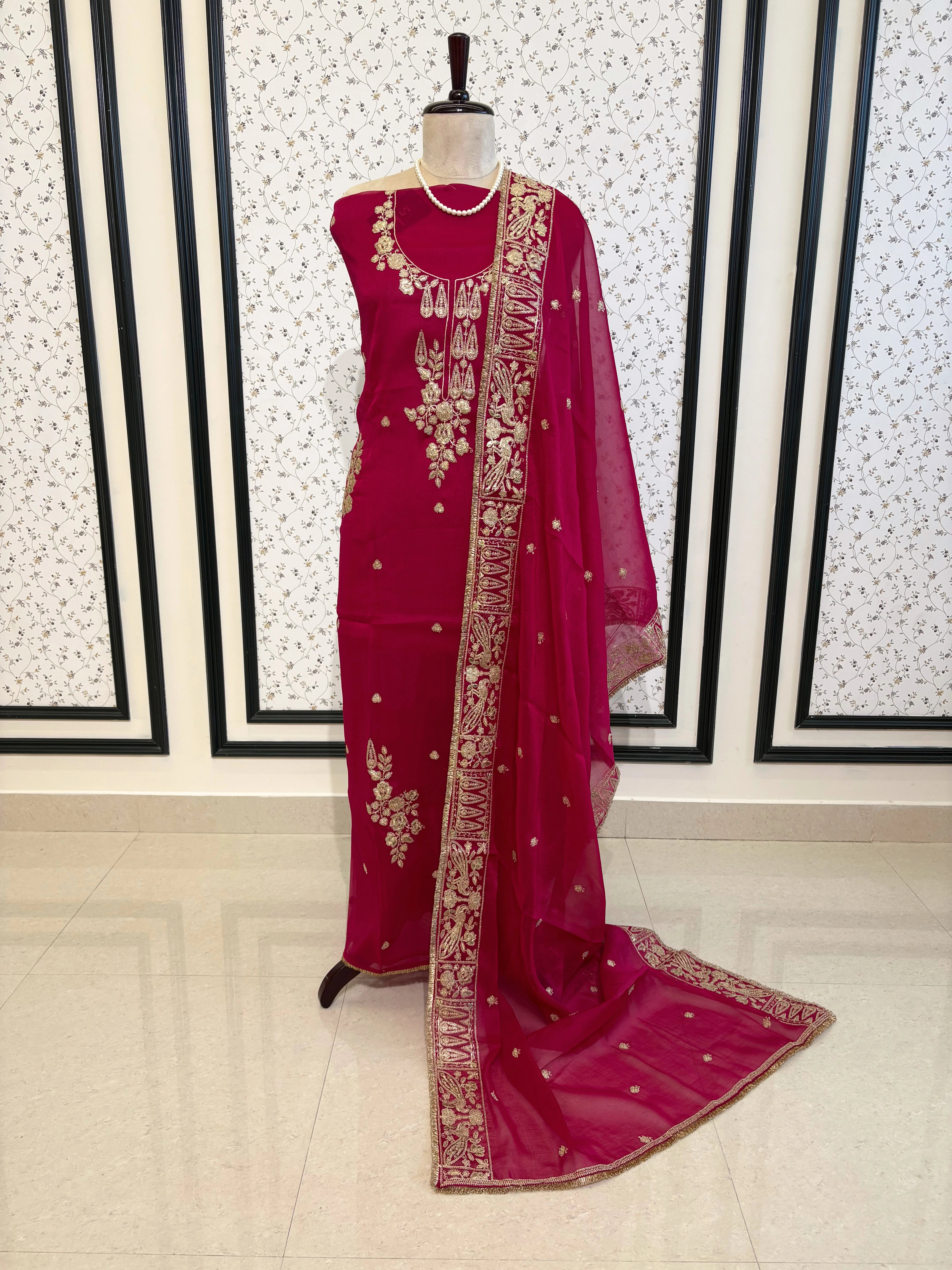 Hot pink organza unstitched suit with golden zari embroidery and embroidered dupatta, ideal for weddings and festive celebrations.