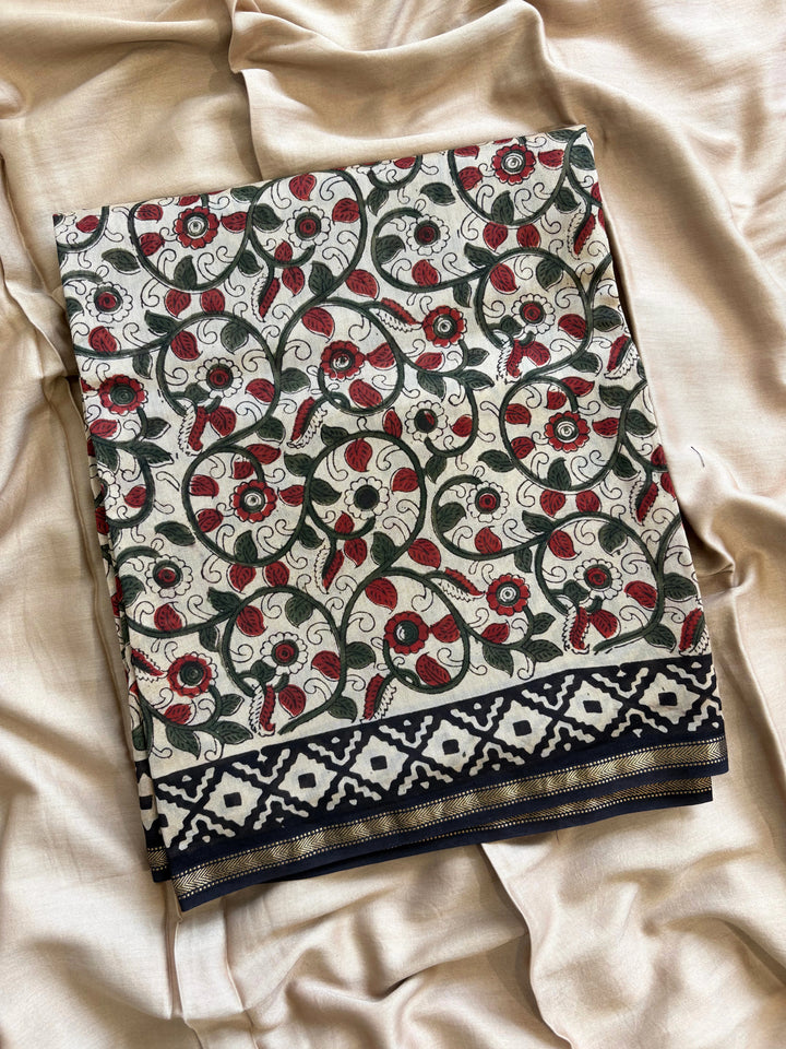 Maheshwari fabric suit with Kalamkari floral print in green, ivory, and maroon tones, featuring traditional hand-block designs and striped dupatta.